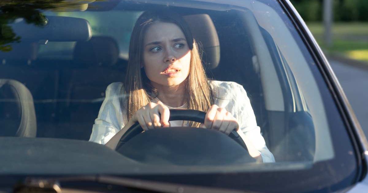 A woman looking through her car's windshield with a distressed expression. Representative Cover Image Source: Getty Images | Dima Berlin