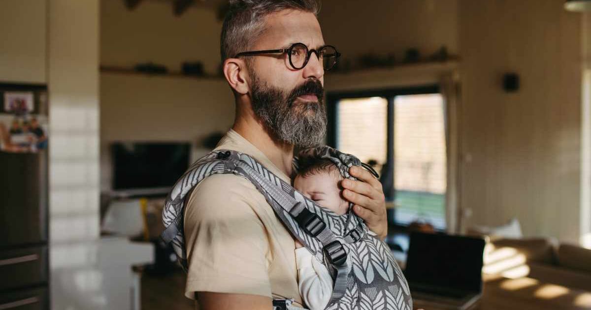Man carrying a baby in a carrier. Representative Cover Image Source: Getty Images | Halfpoint Images