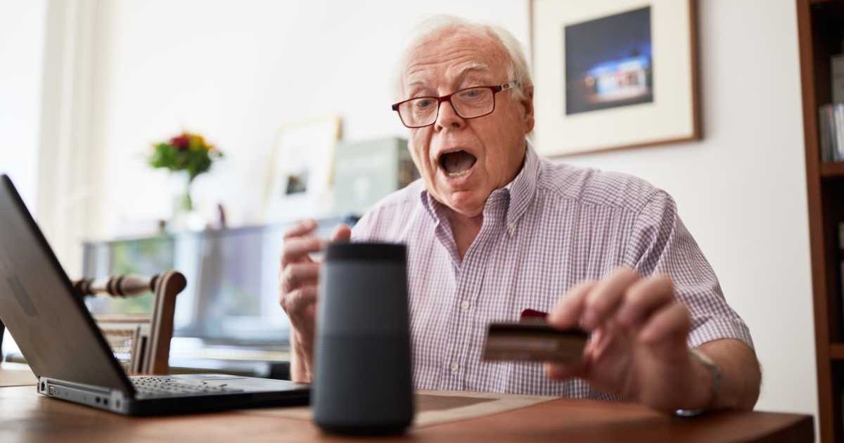 Old man looking excited while looking at laptop screen with a card in hand. Representative Cover Image Source: Getty Images | Luis Alvarez