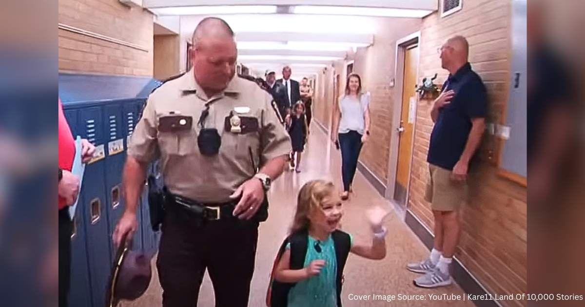 The little girl with the police officer on her first day of kindergarten. (Cover Image Source: YouTube | Land of 10,000 Stories by Kare11)