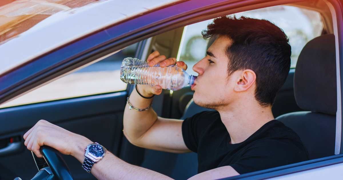 A man inside a car on a hot day and drinking water from a plastic bottle. (Representative Cover Image Source: GETTY| Art-Of-Photo)