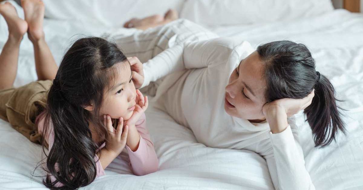 Mom talking to young daughter in bed. Representative Cover Image Source: Pexels | Ketut Subiyanto
