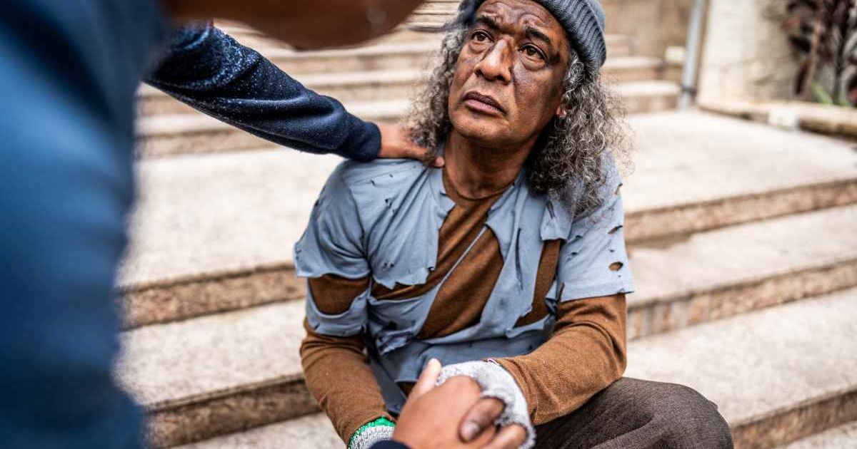 Person talking to a homeless man. Representative Cover Image Source: Getty Images | FG Trade