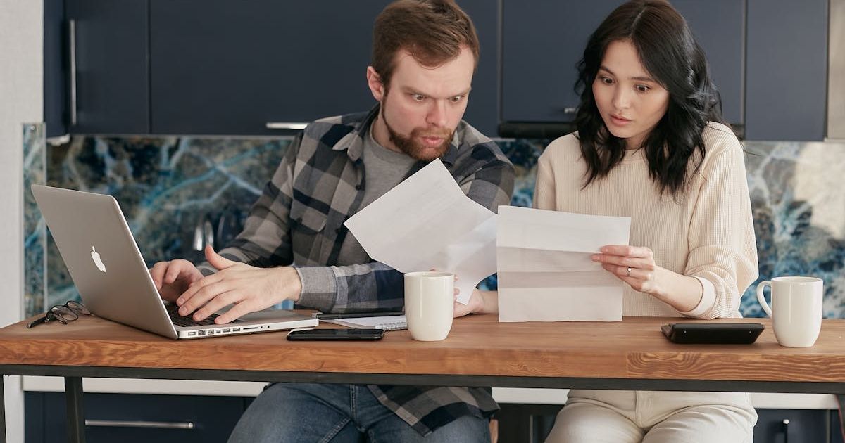 Couple looking at papers with surprised faces. Representative Cover Image Source: Pexels | Mikhail Nilov