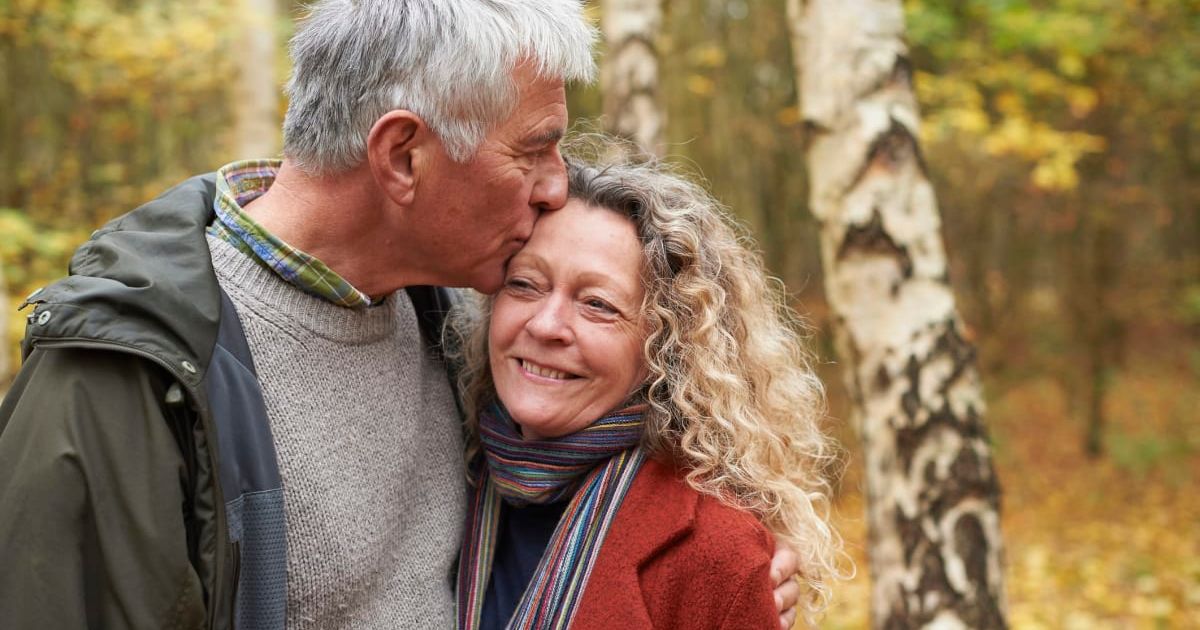 Old couple giving each other a hug as the man kisses his wife's head. Representative Cover Image Source: Getty Images | Richard Drury