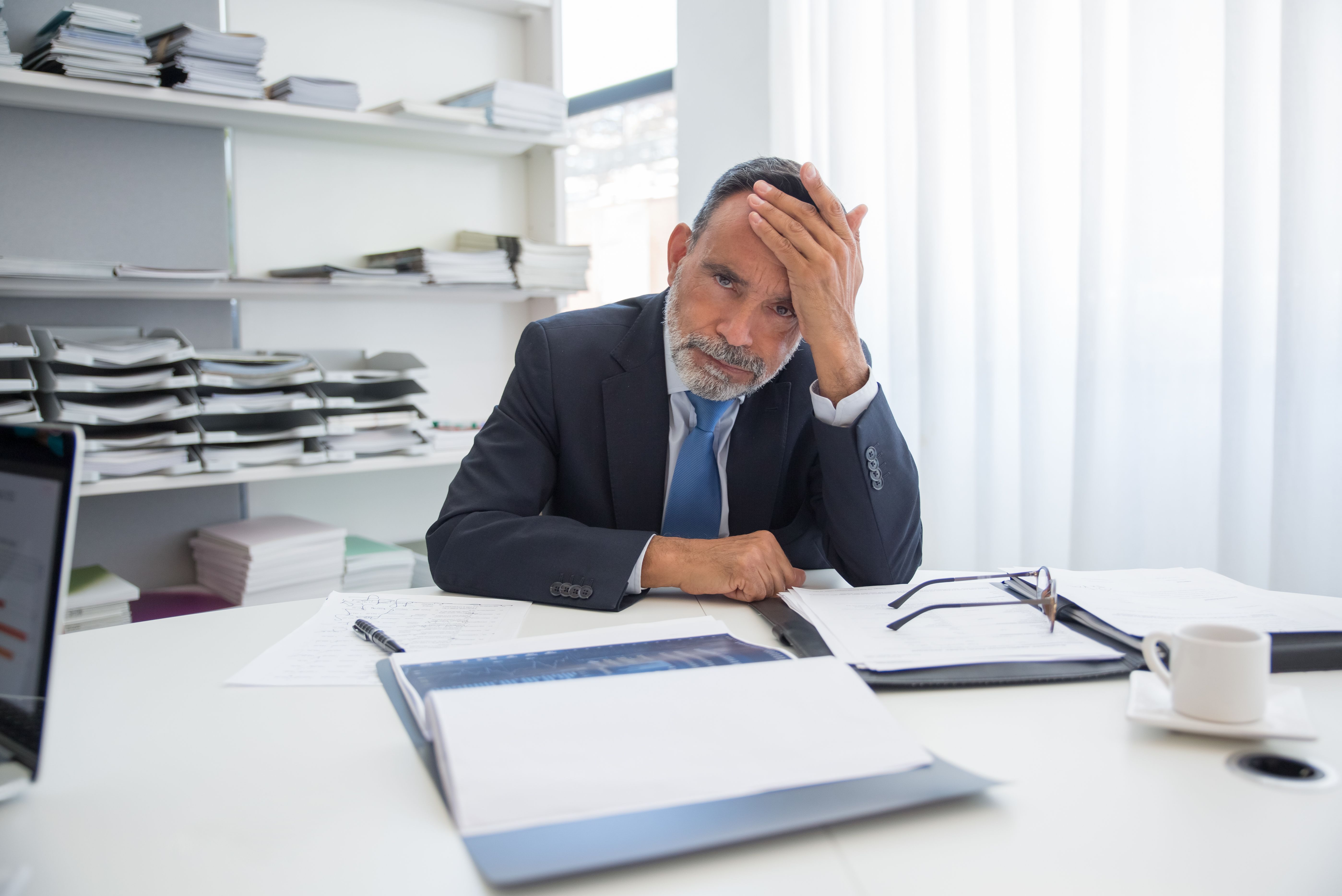A boss struggling and uneasy in the office.