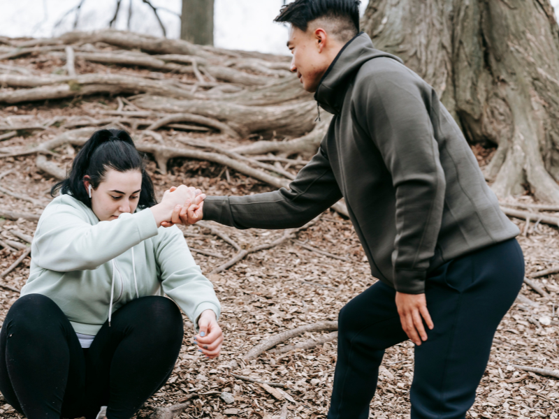 Man helping a woman get up.