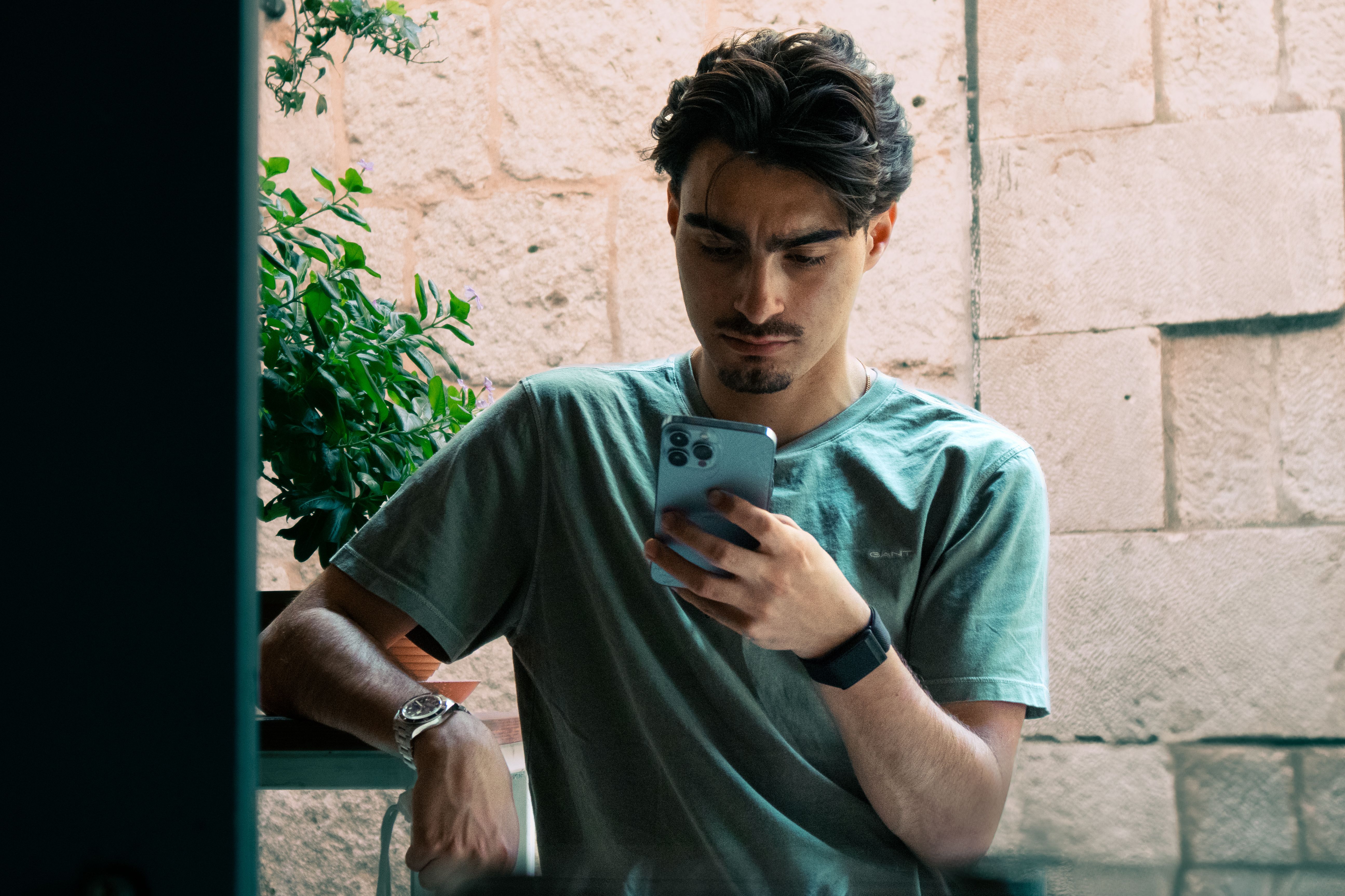 A man looks at his phone disappointedly.