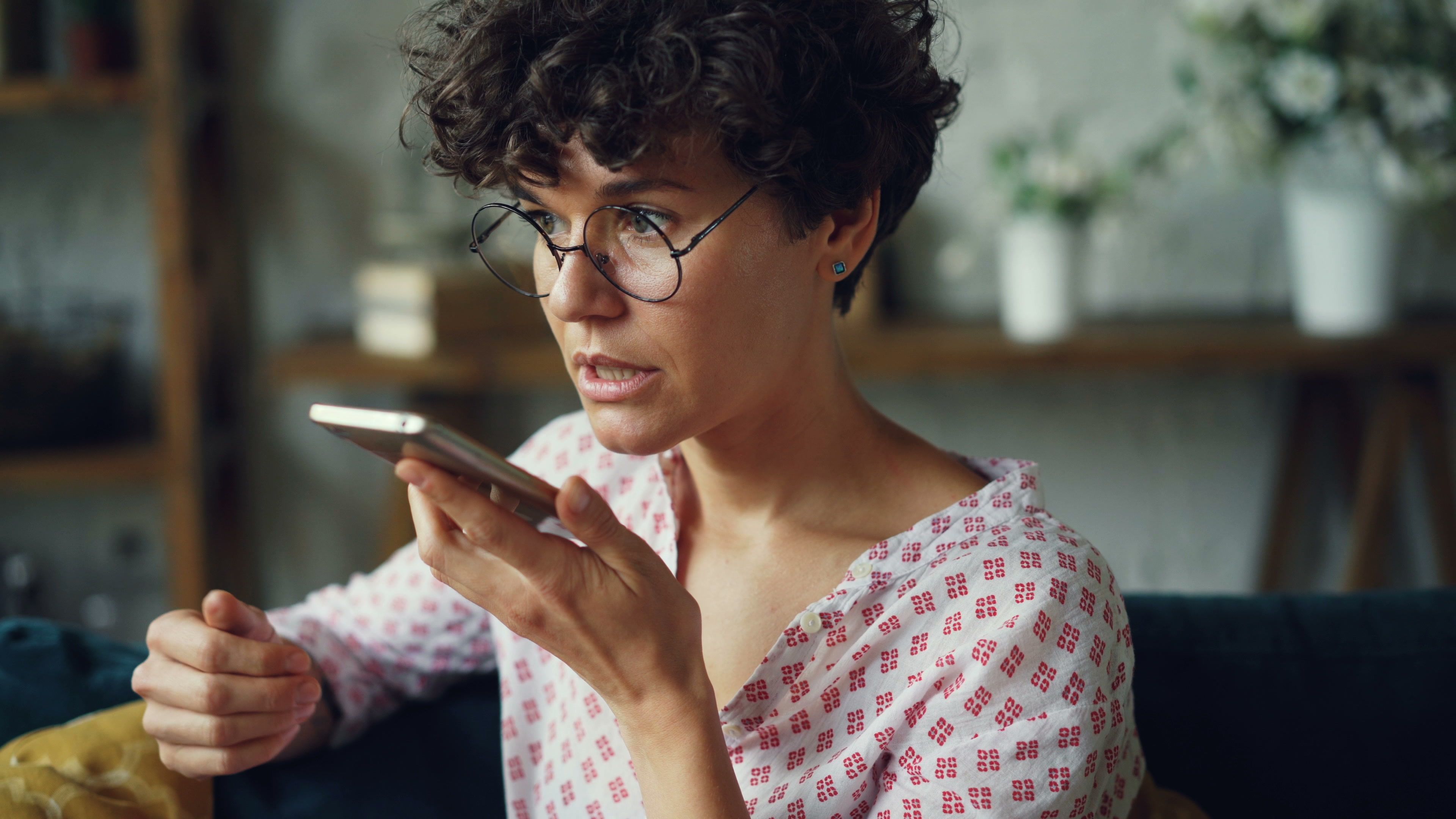 A woman records herself speaking seriously on the phone.