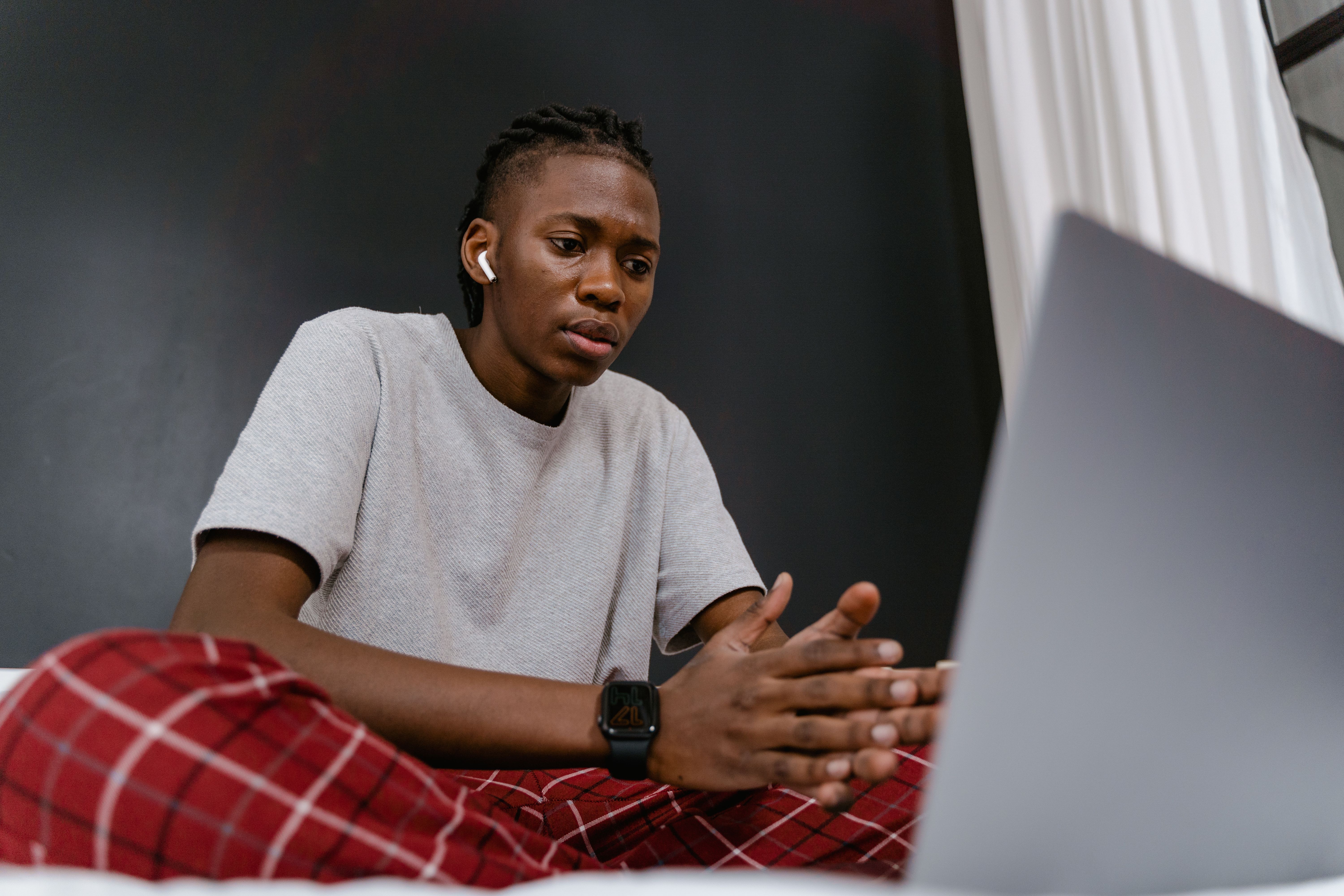 A man is  looking at his laptop disappointed.