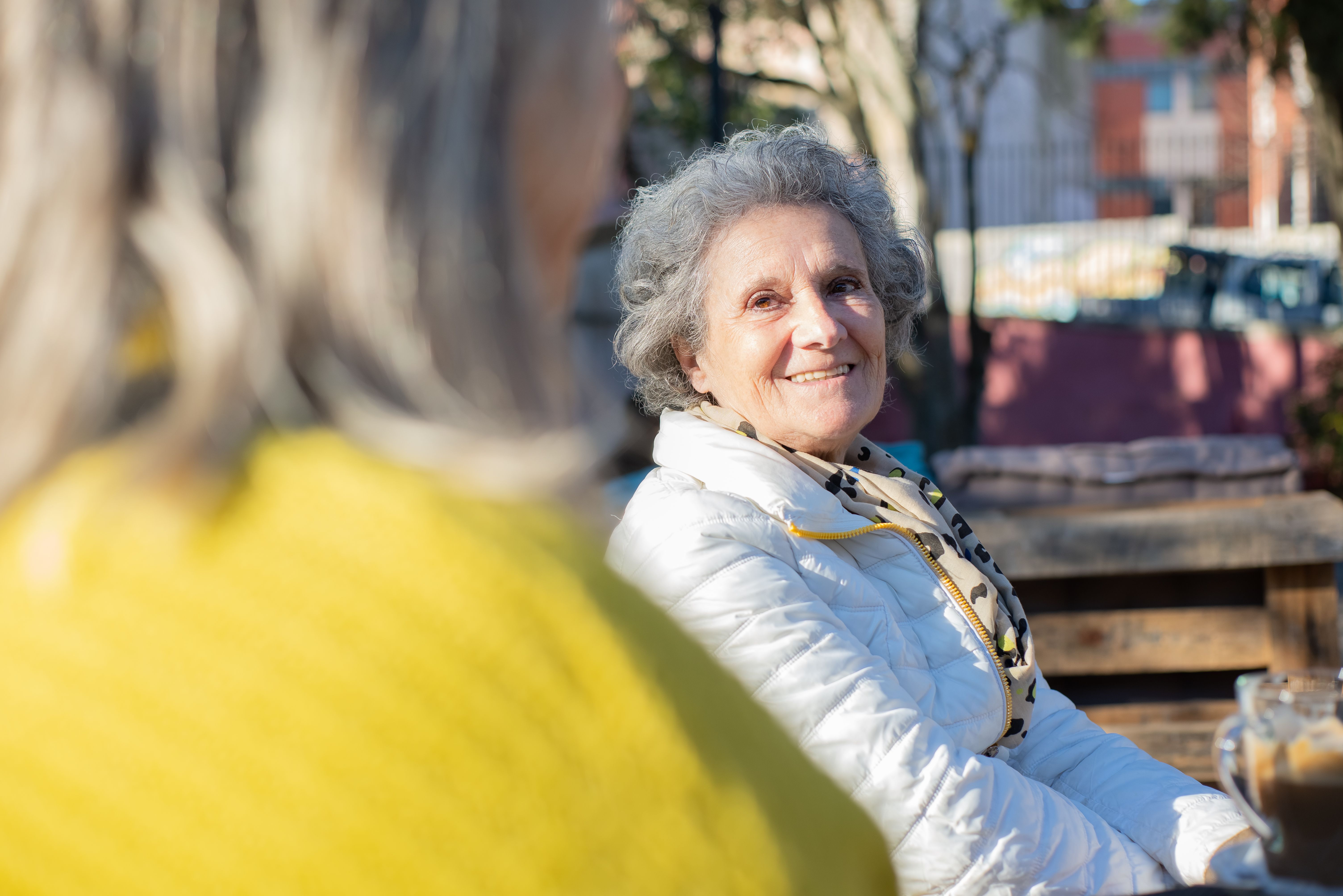 An elderly woman chatting with someone.