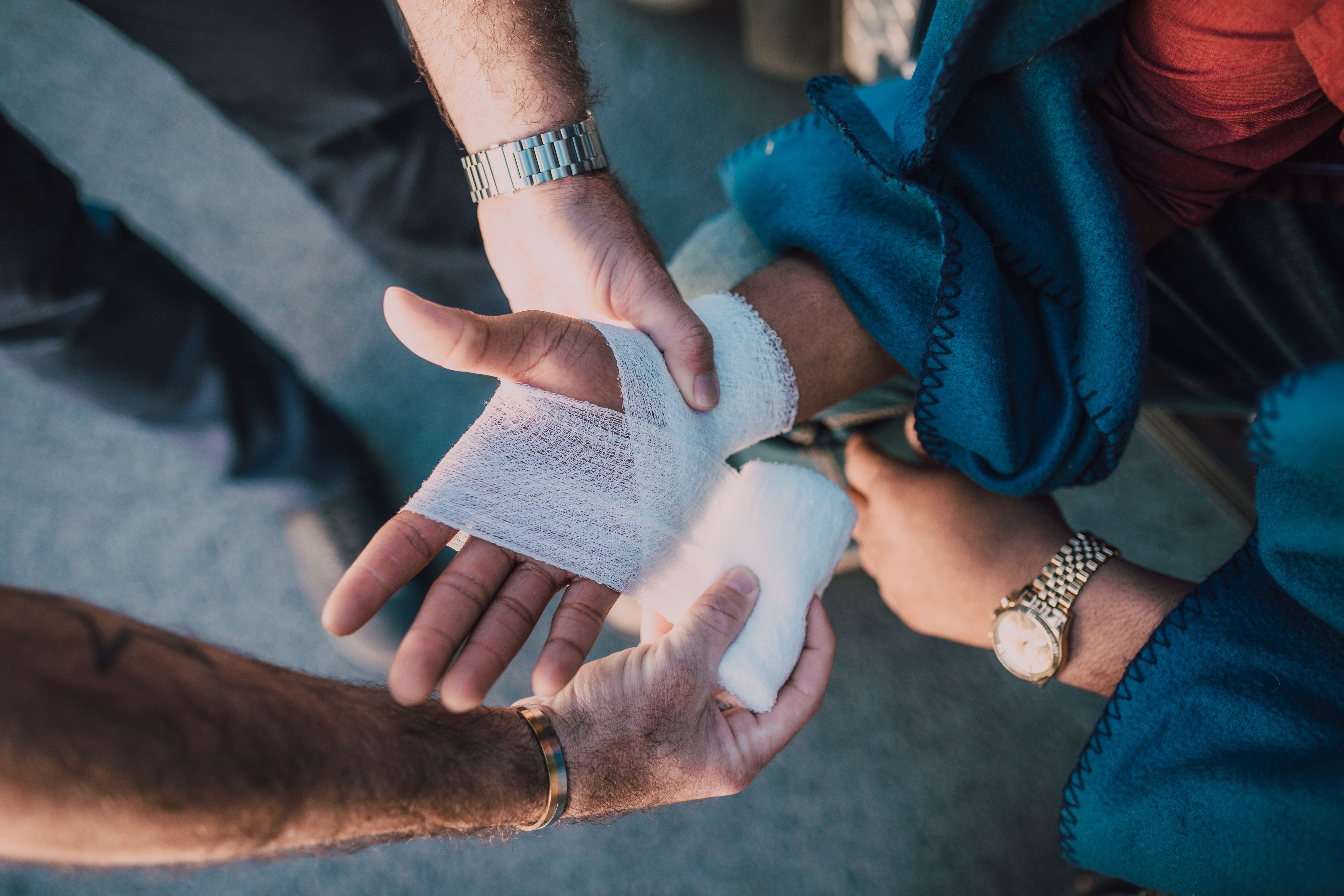 A man getting his wrist bandaged after getting injured.