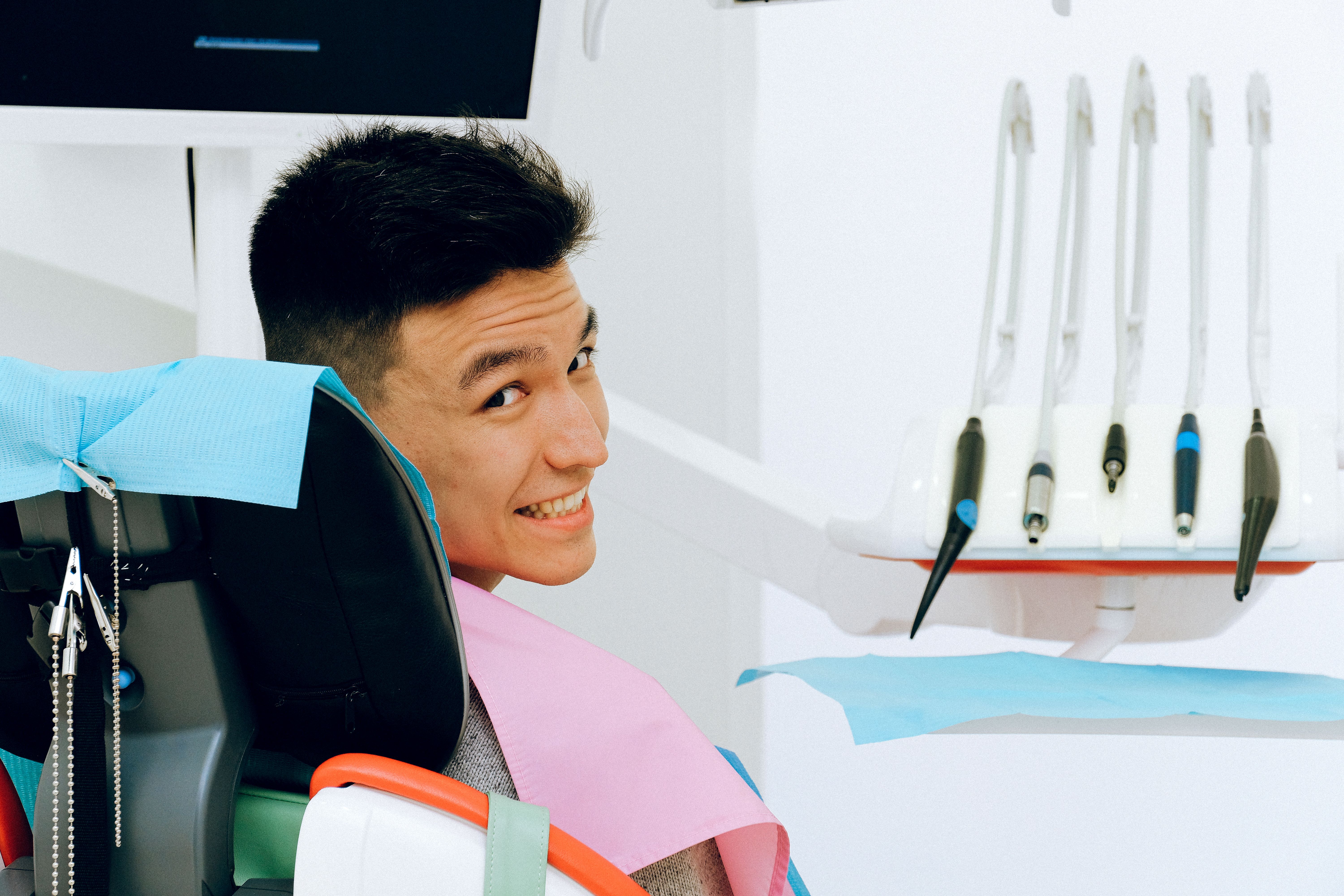 A man in dental clinic smiles absurdly.
