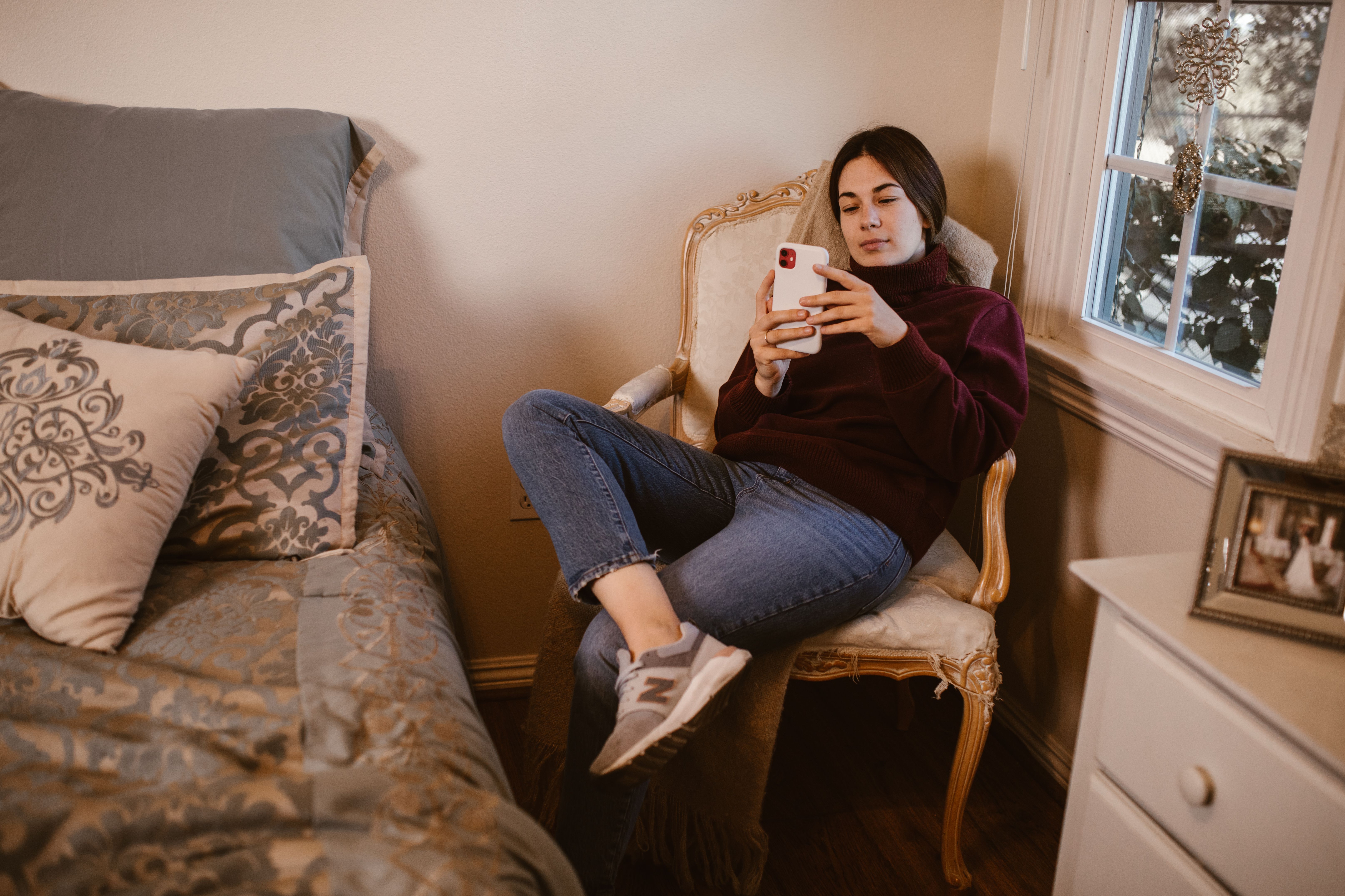 A woman looks disappointedly at her phone.