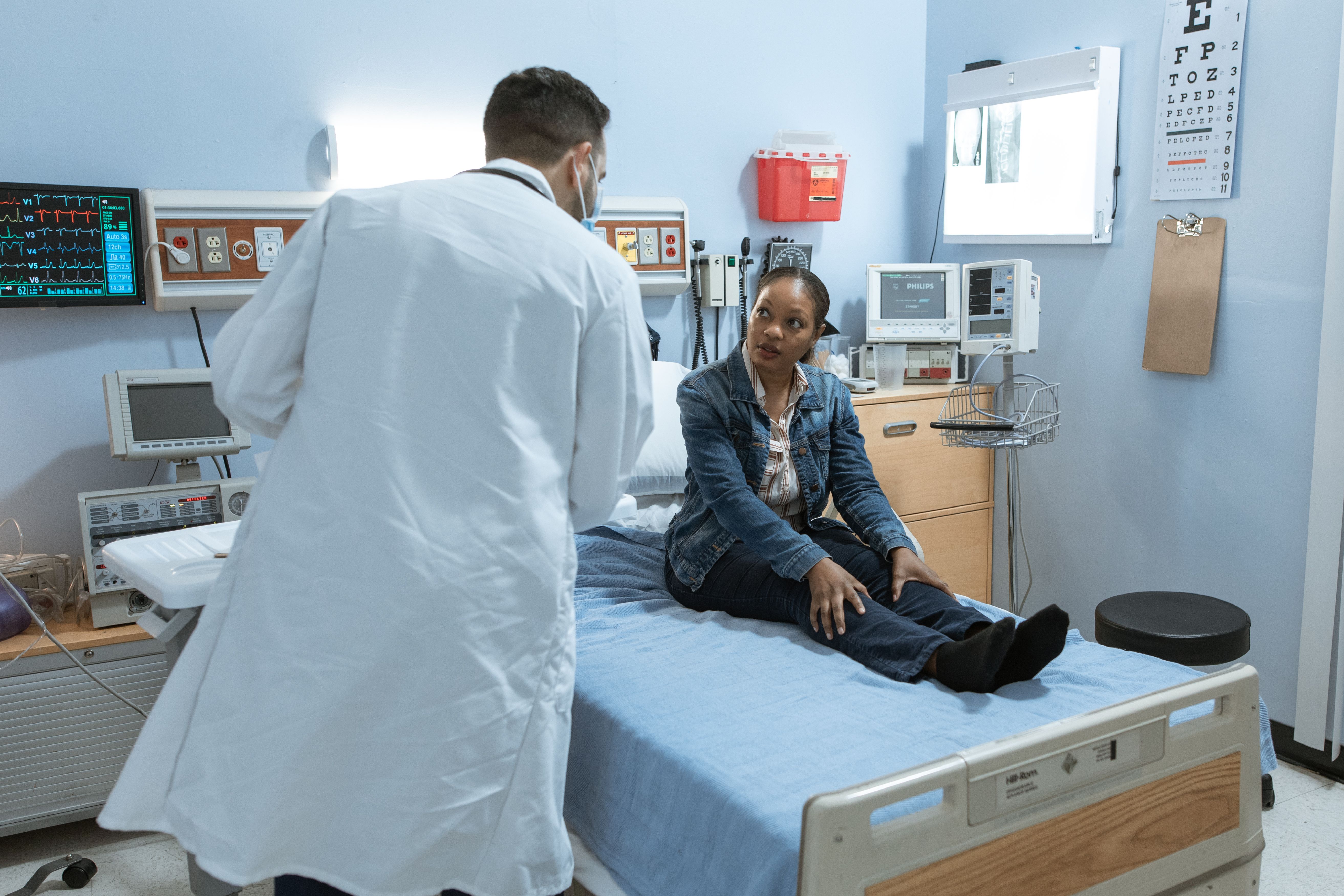 A woman in the hospital, speaking with a doctor.