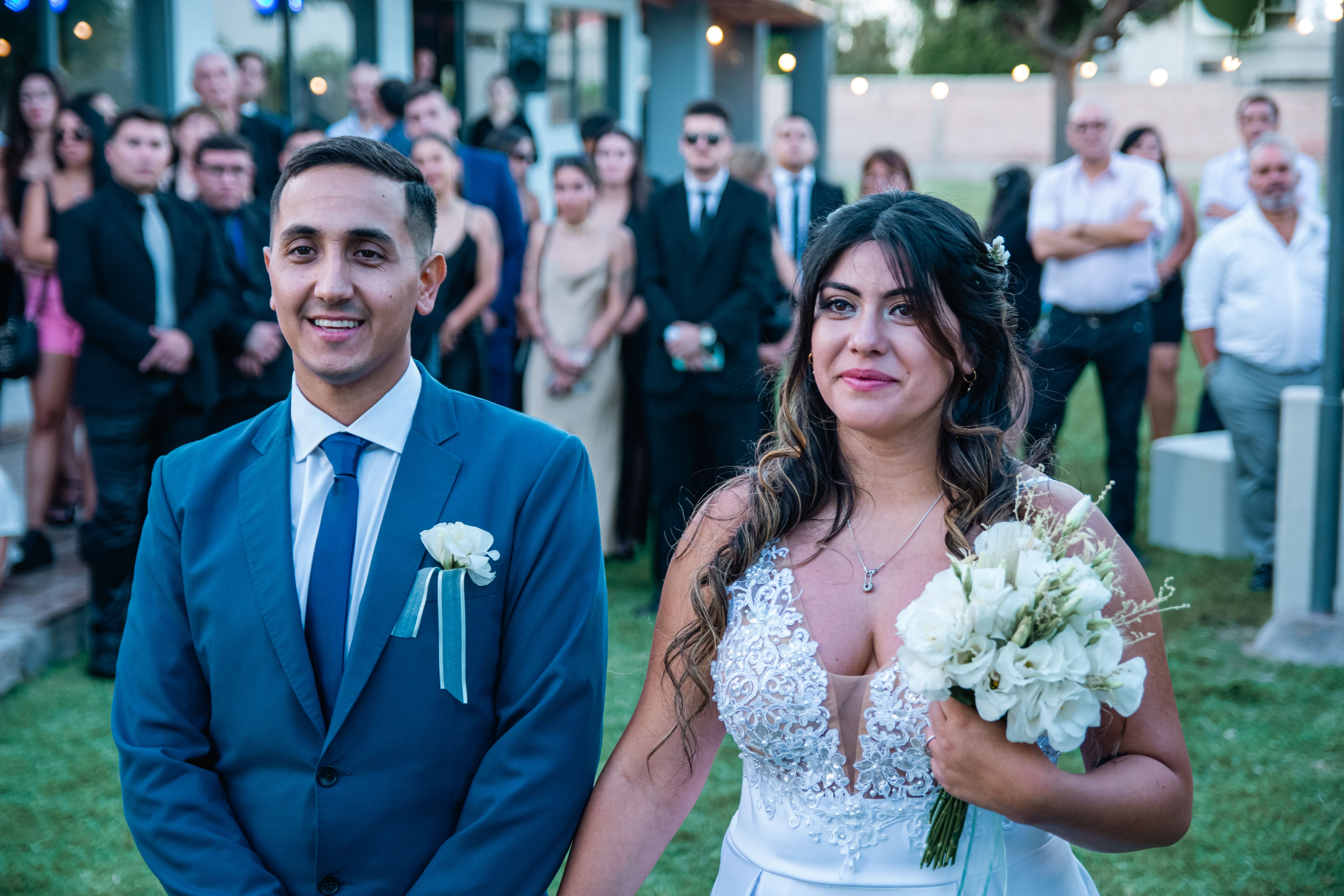 Guests watch as bride and groom share first kiss.