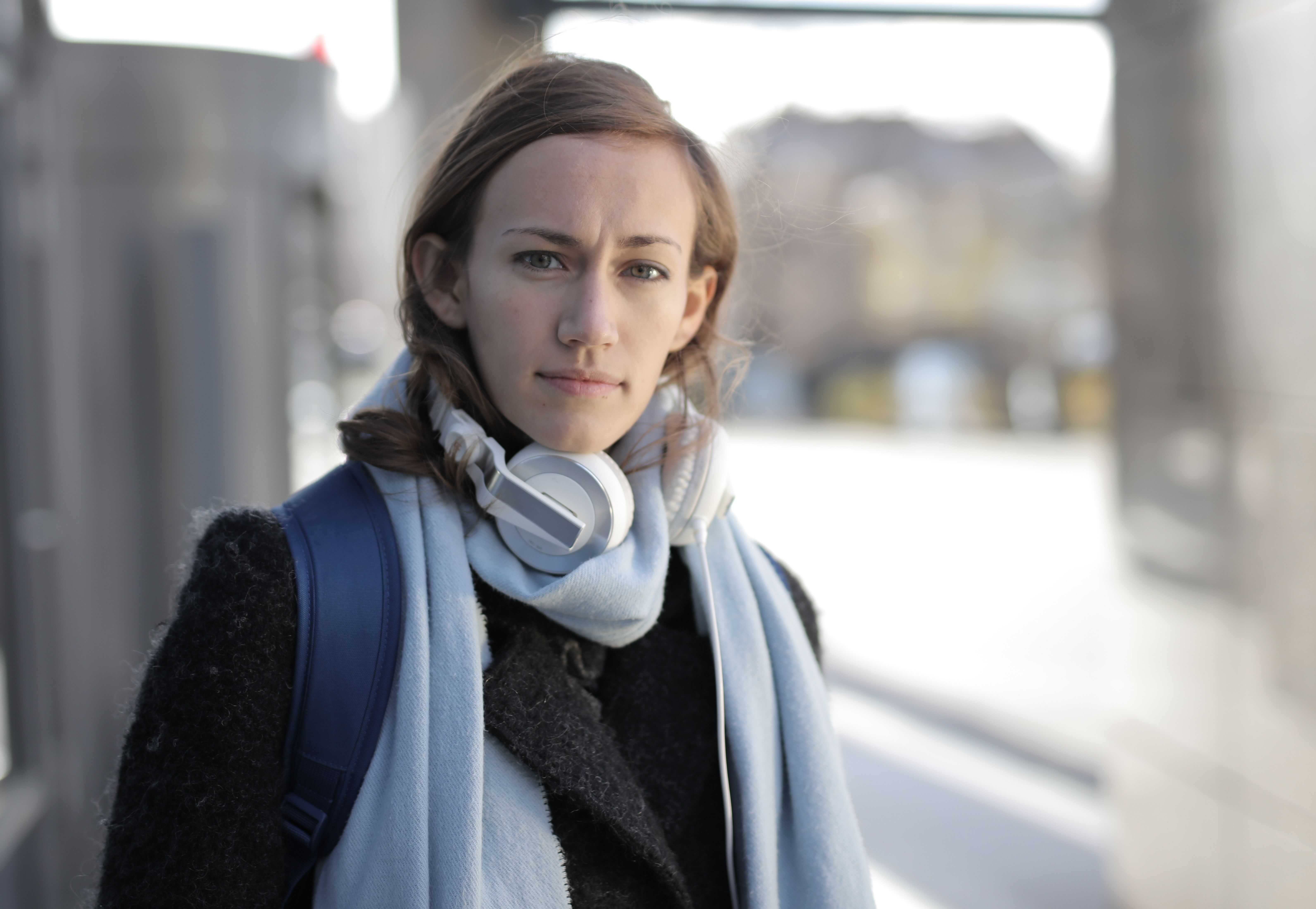 A woman at an airport looks on disappointedly.