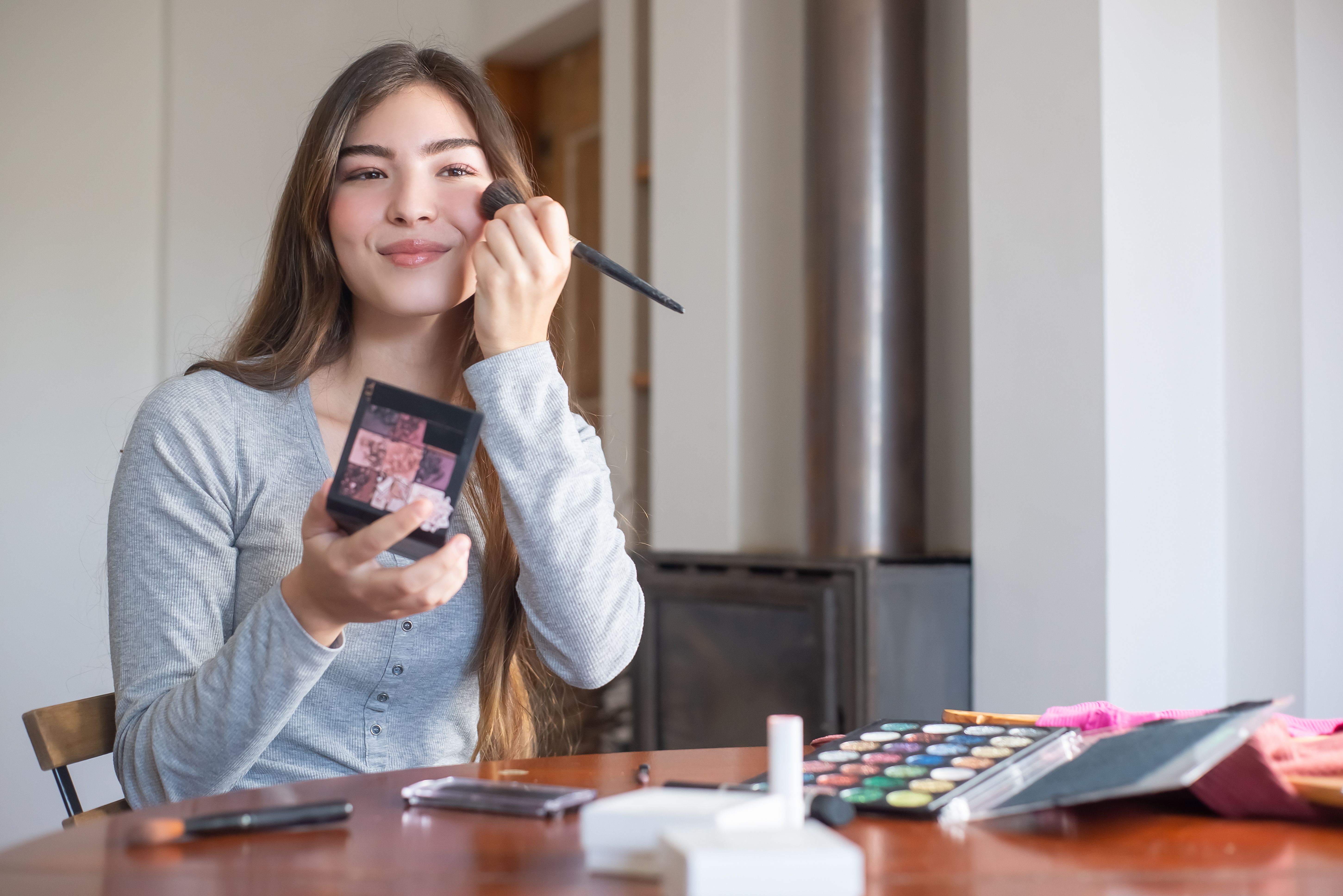 A woman is applying makeup.