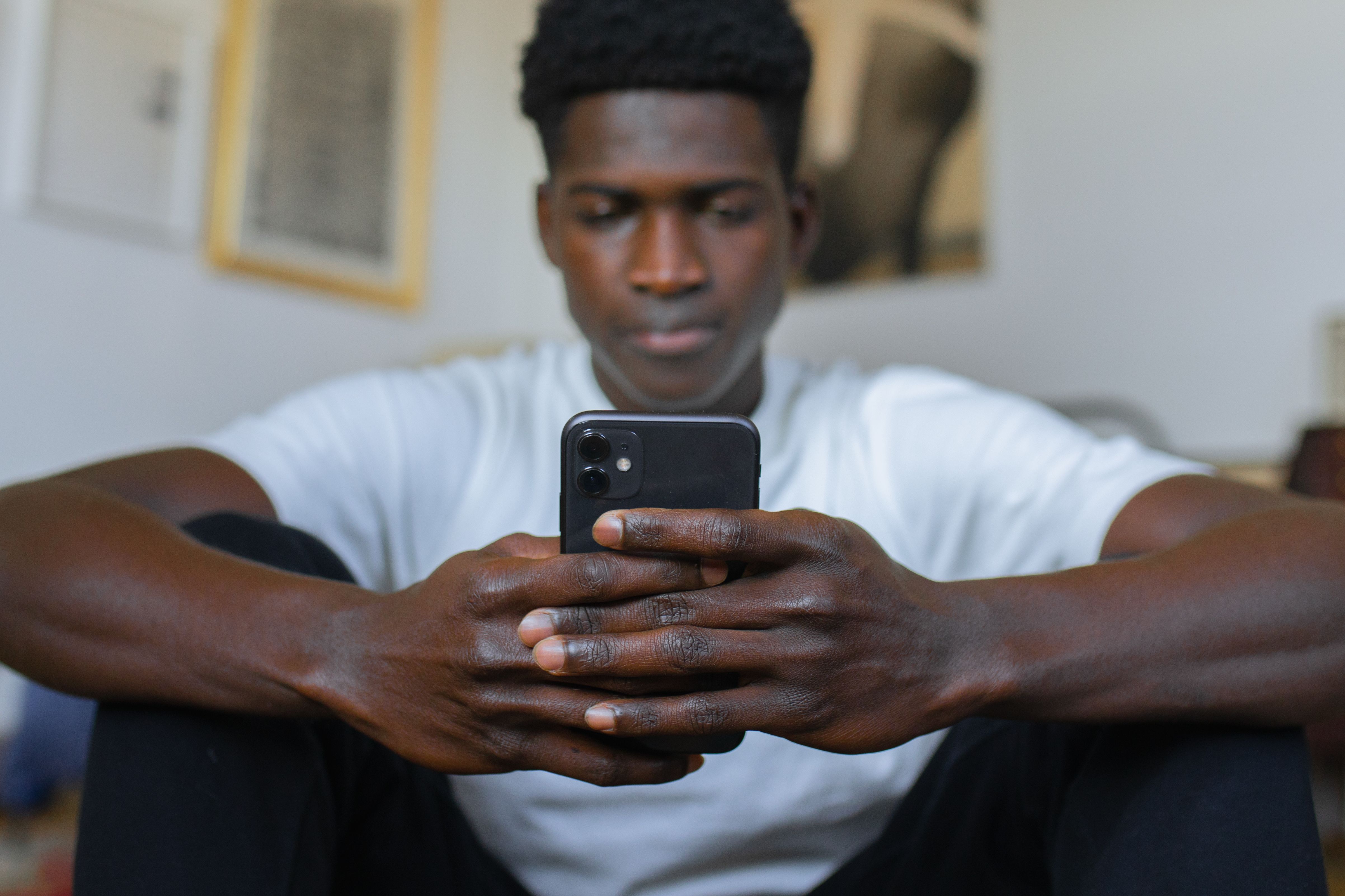 A man looks angry while texting.