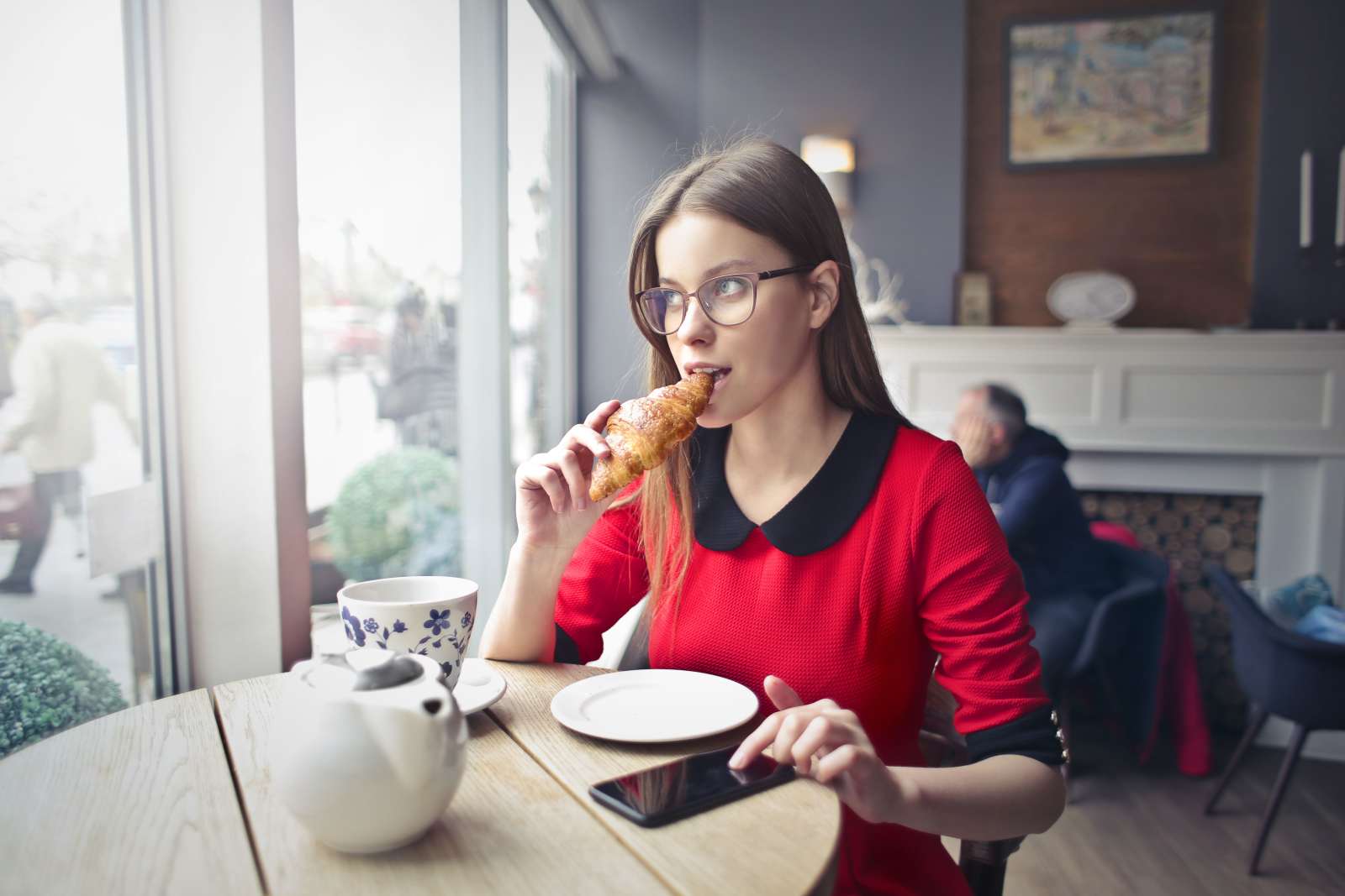 A woman is eating a croissant.