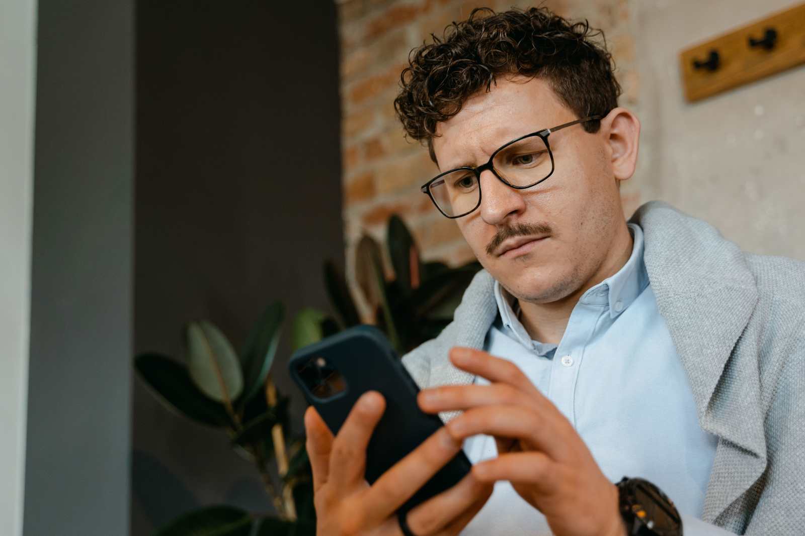 A man looks annoyed while texting.
