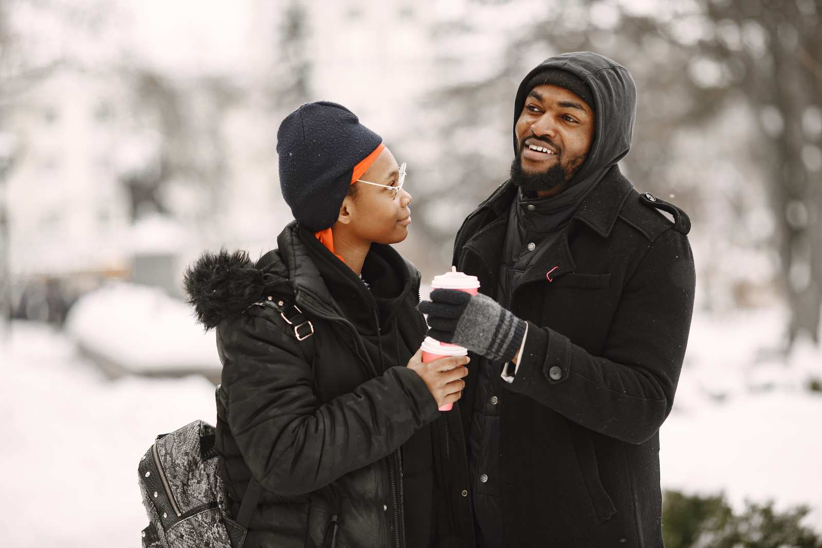 A man and a woman in winter clothing enjoying hot drinks outdoors on a snowy day. (Representative Image Source - Pexels | Gustavo Fring)