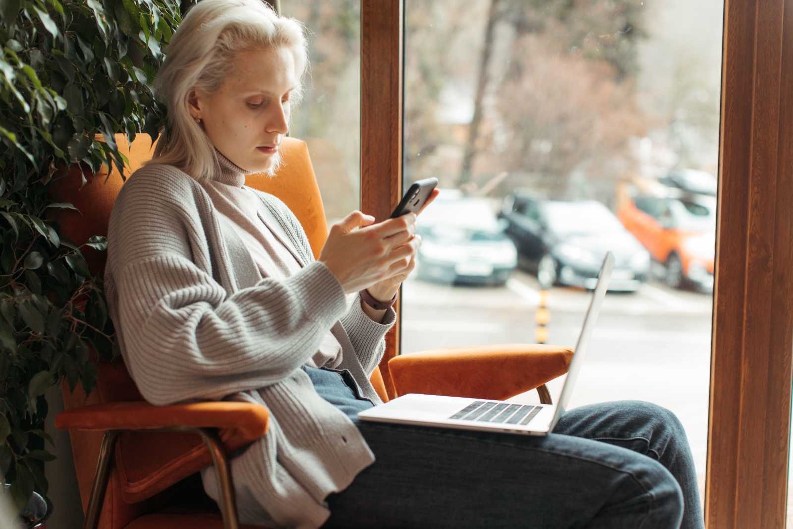 A woman looks at her phone in confusion.