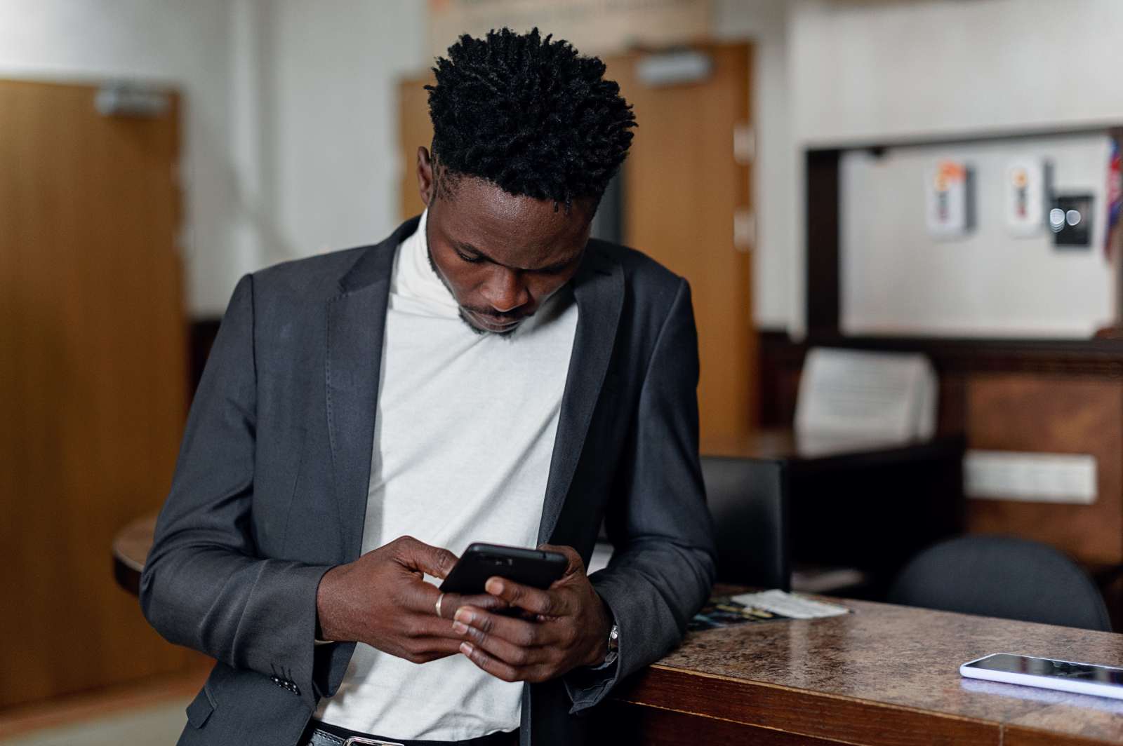 A man is engrossed in texting on his phone.