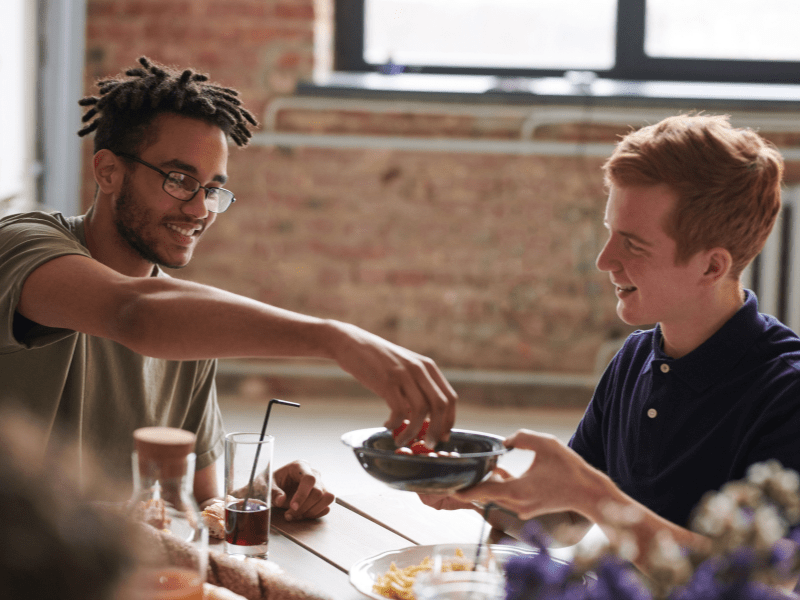 Two friends sharing food.