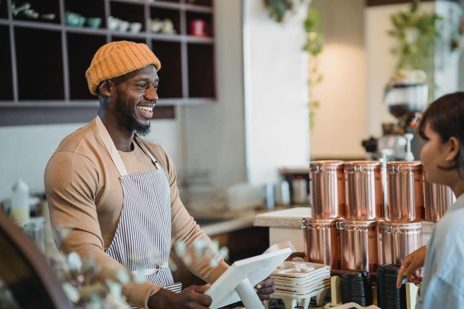 A cashier smiles while speaking with customers.