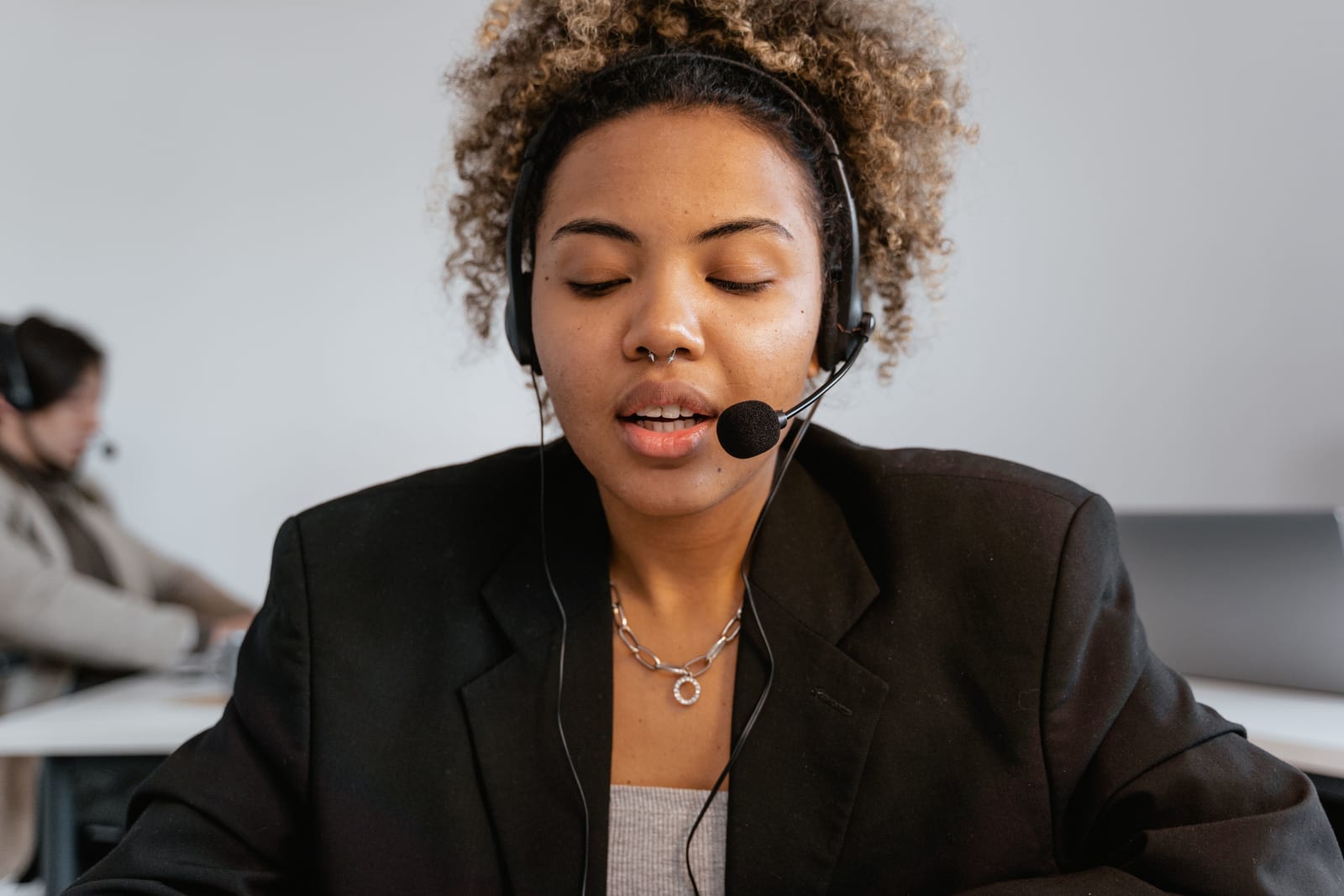 A woman is speaking to a caller using her headset.