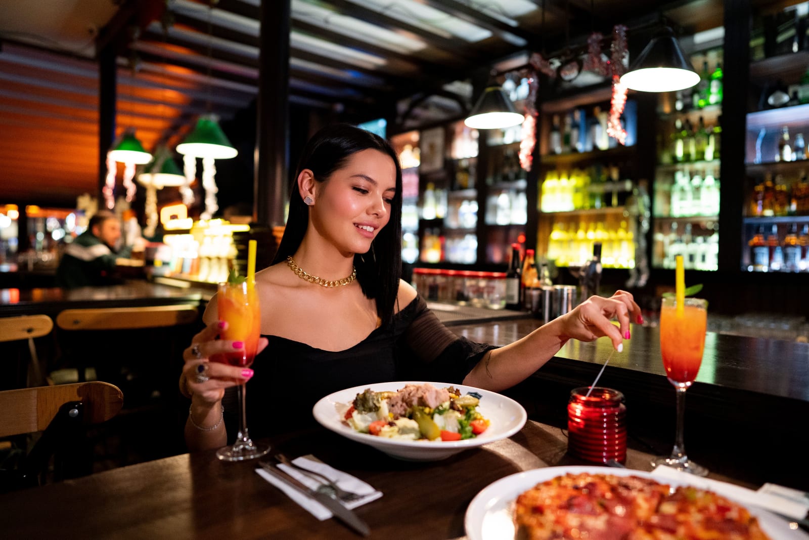 A woman enjoying a stylish dinner in a cozy restaurant. (Representative Image Source: Pexels | Kadir Avşar)