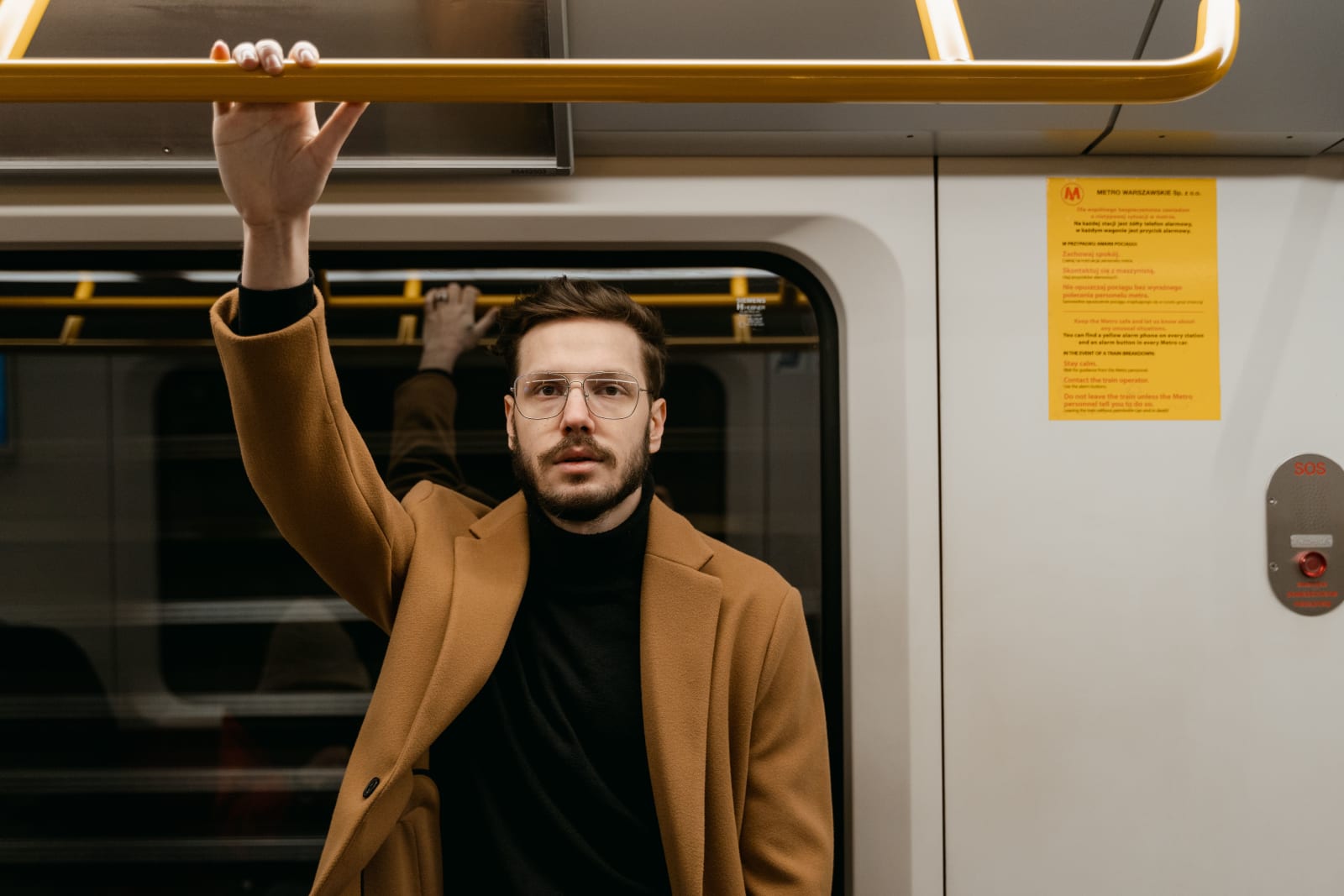 A man is staring from a train.