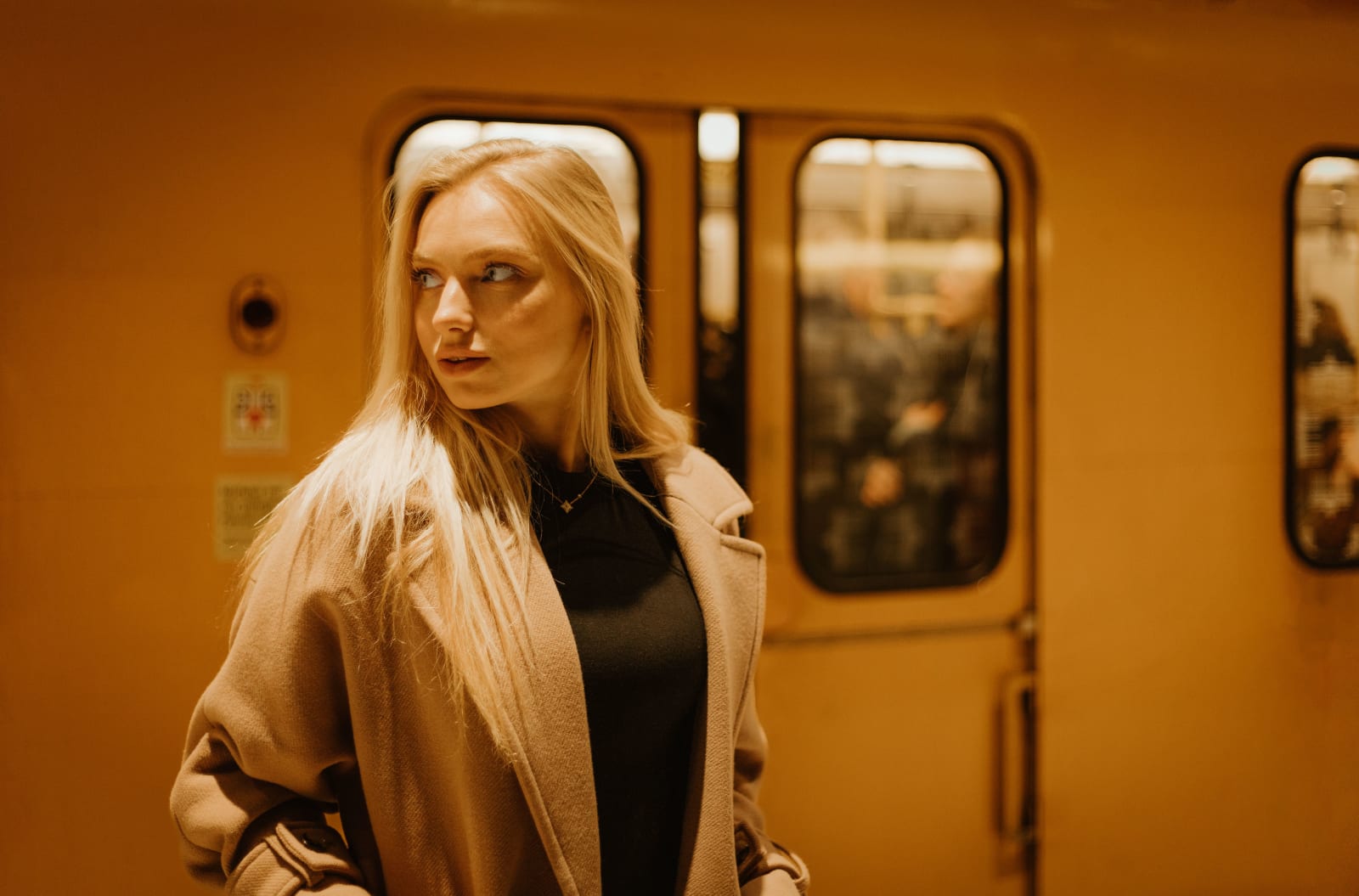 A woman at a train station looking around intently.