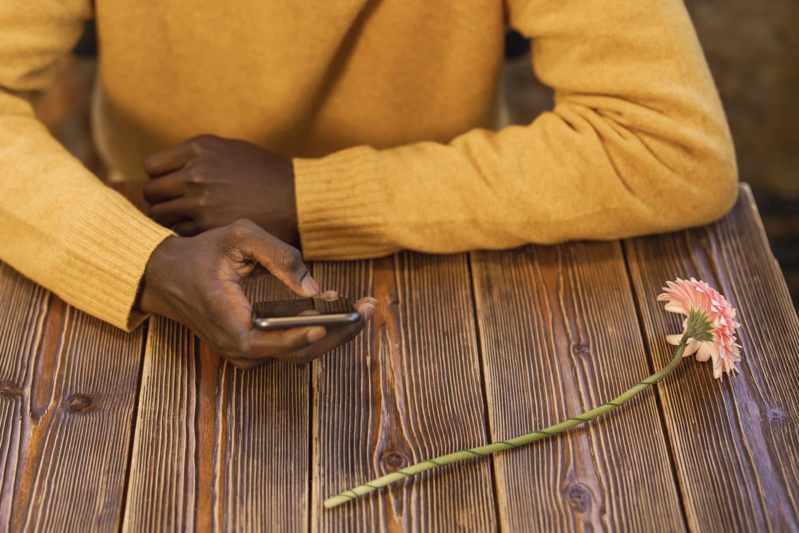 A man texting on his phone while waiting for a date.