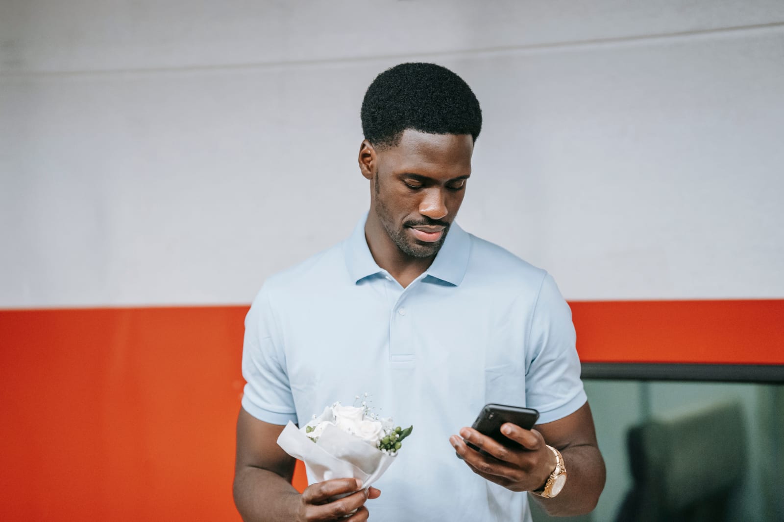 A man holding flowers and waiting for someone.