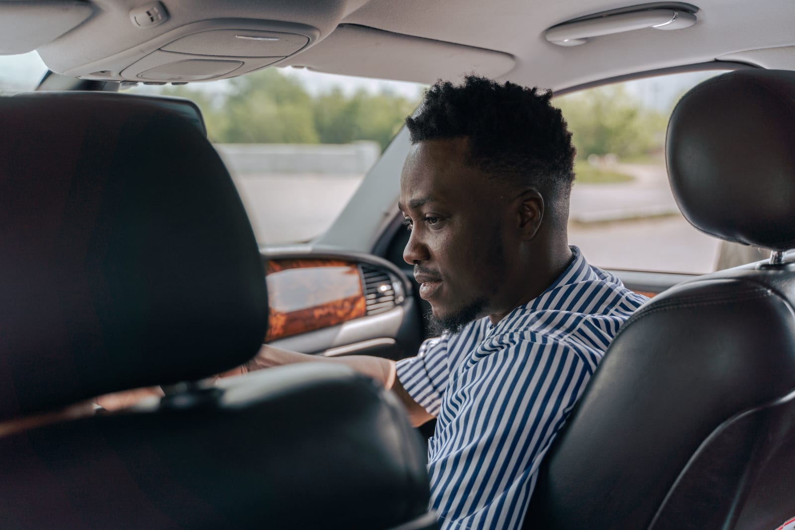 A man in his car talking to someone.