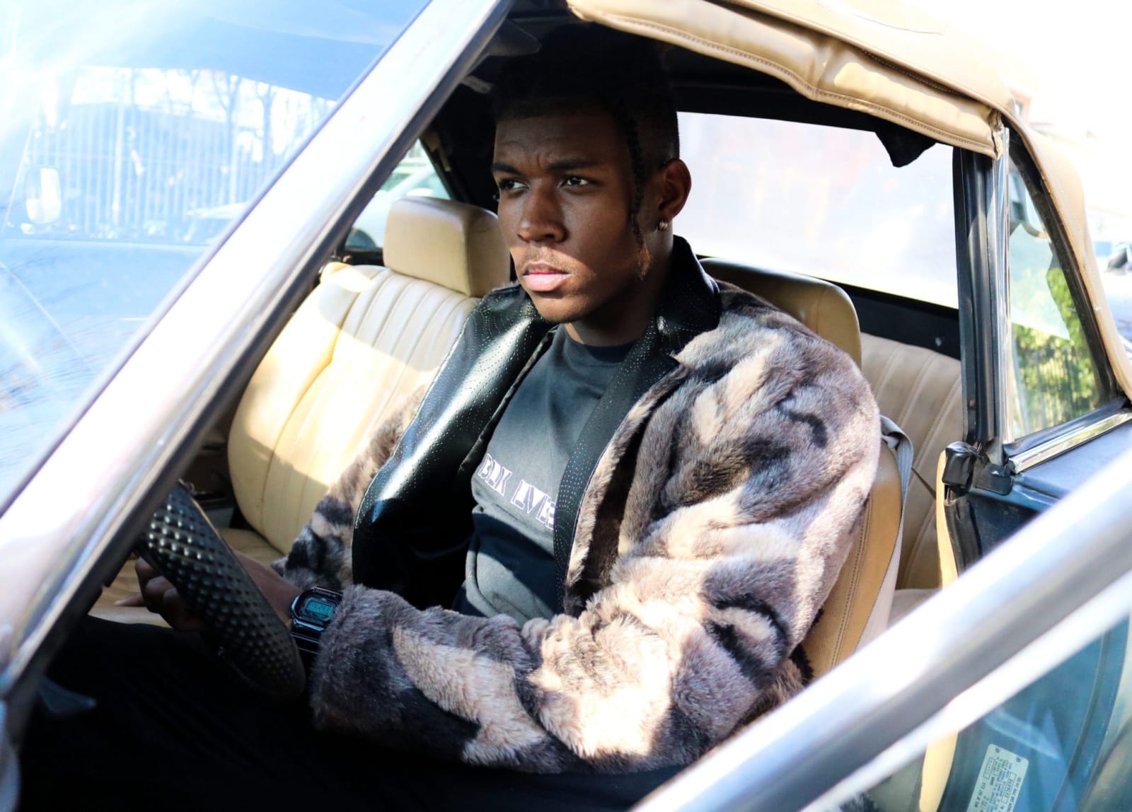 A man sitting and pondering deeply in his car.