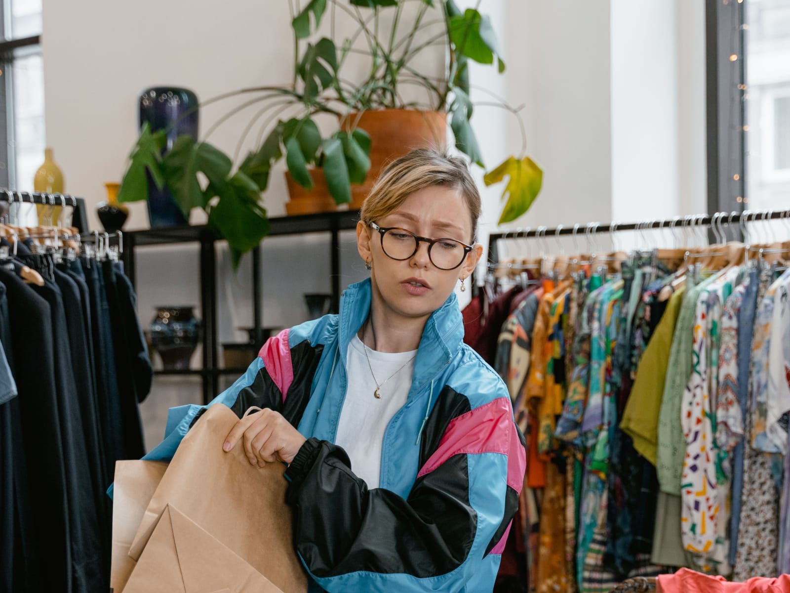 Annoyed woman holding a paper bag in a stylish vintage clothing boutique, indoors. (Representative Image Source: Pexels | MART Production)