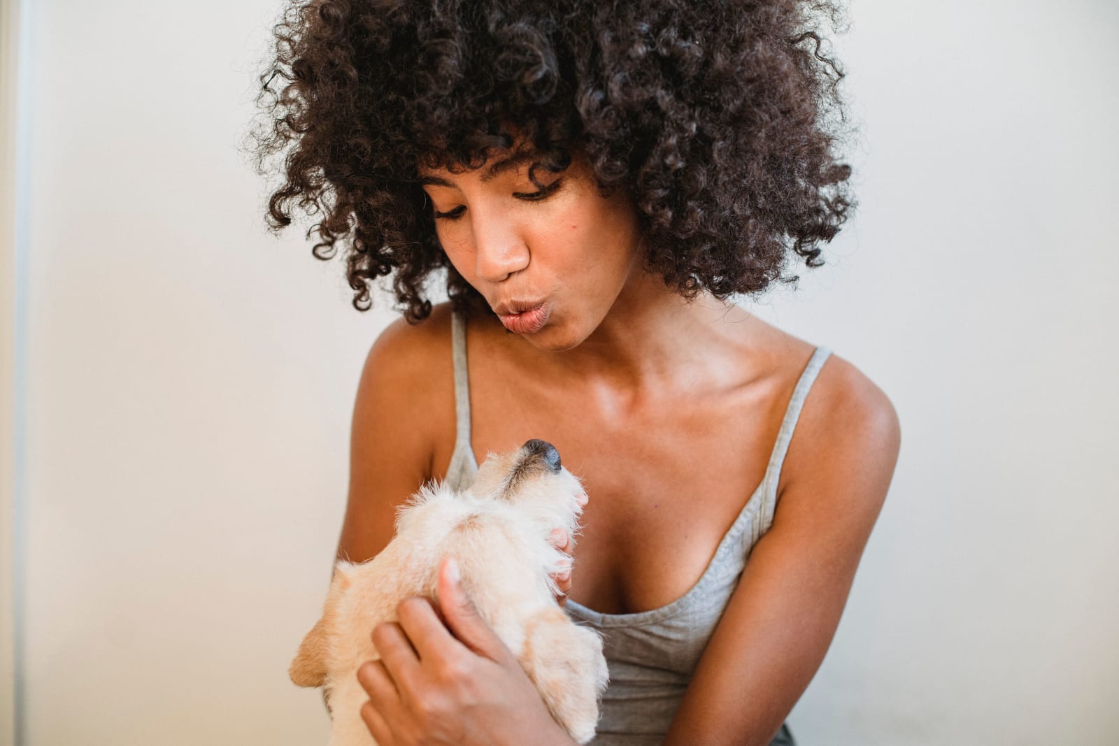 A woman playing with her dog affectionately.
