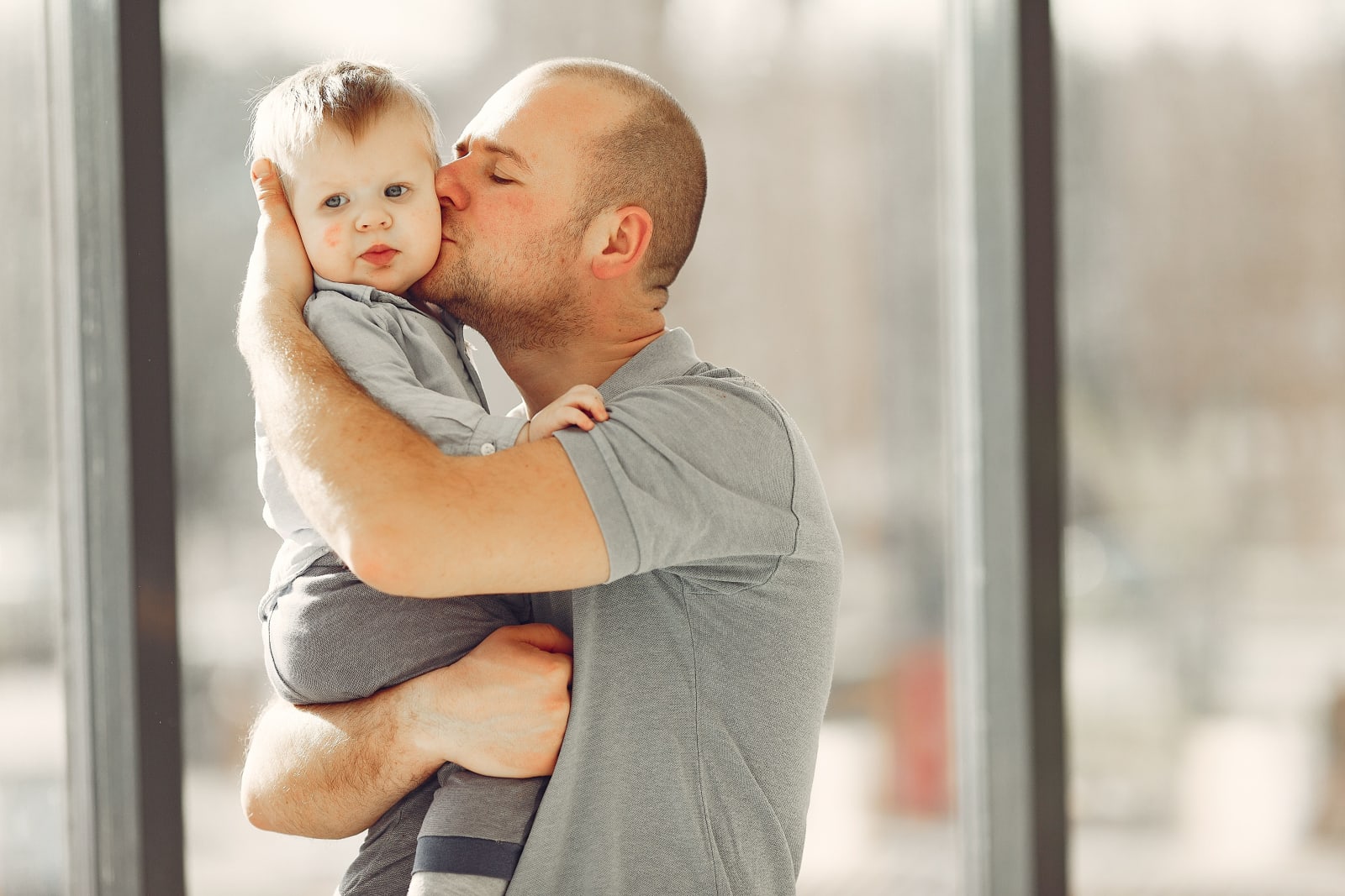 A man carrying his toddler son in an office.