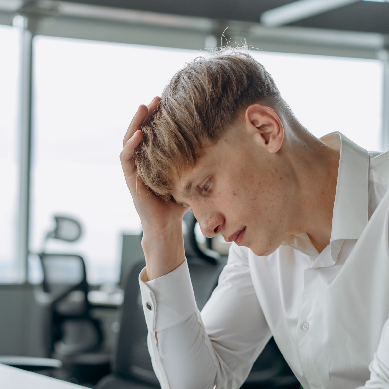 Man feeling stressed and exhausted in a modern office setting. (Representative Image Source: Pexels | Michail Nilov)