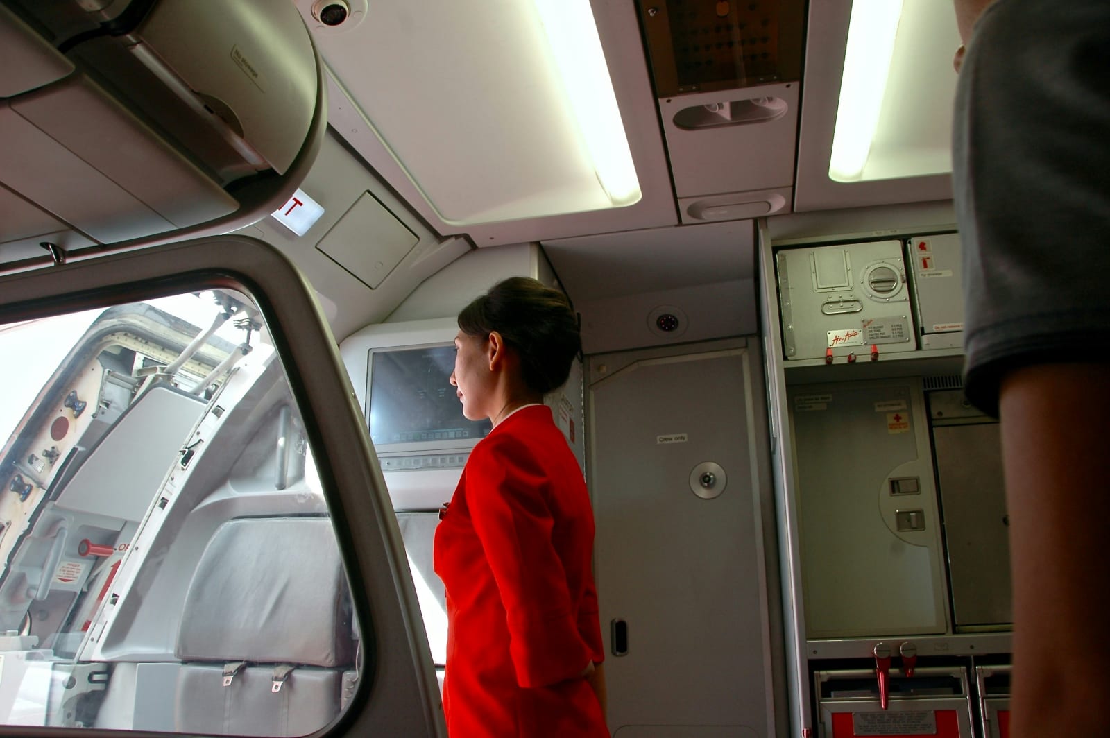 A flight attendant welcoming passengers.