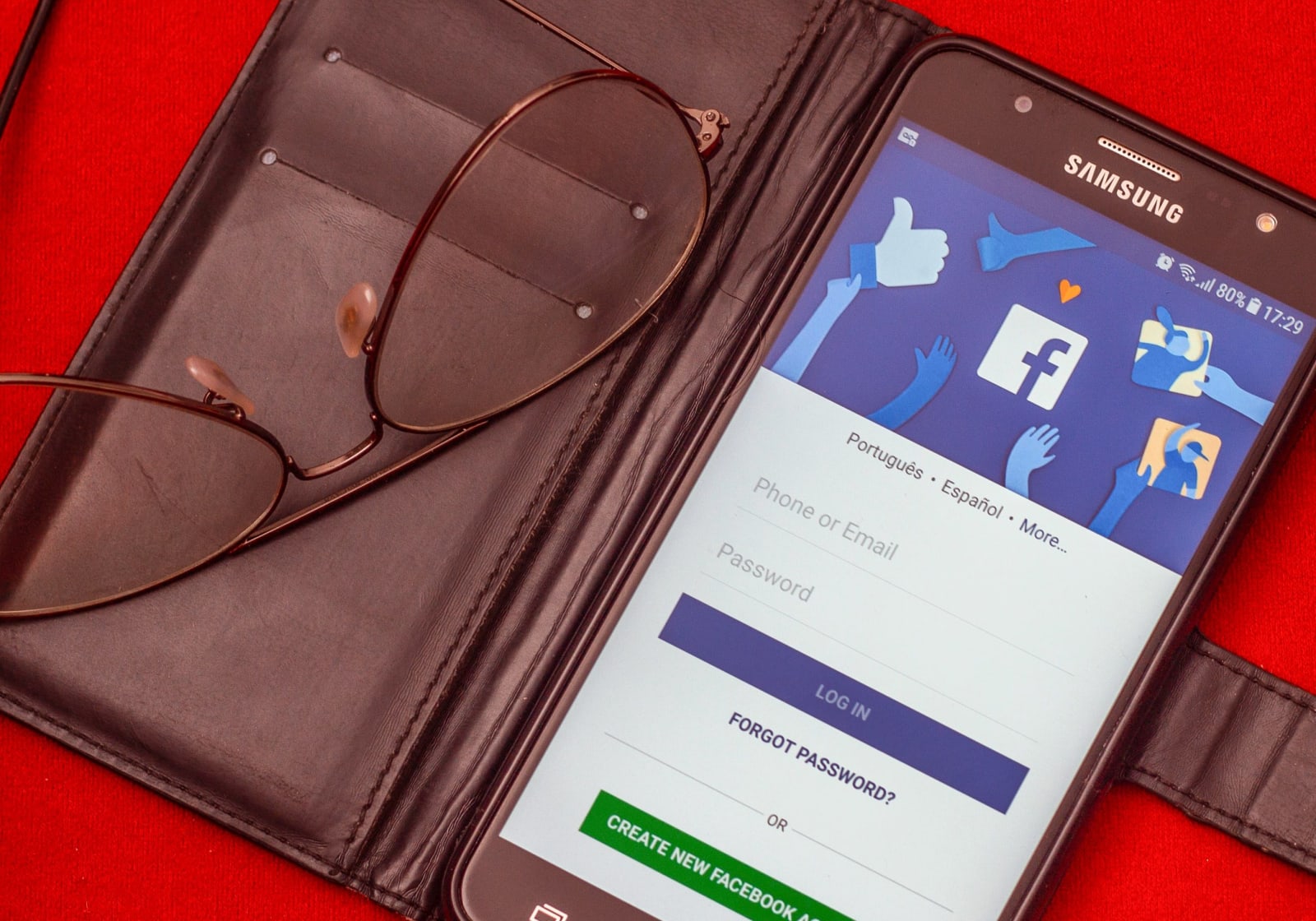 Close-up of a smartphone displaying a Facebook login screen next to eyeglasses. (Representative Image Source: Pexels | Anderson Guerra)