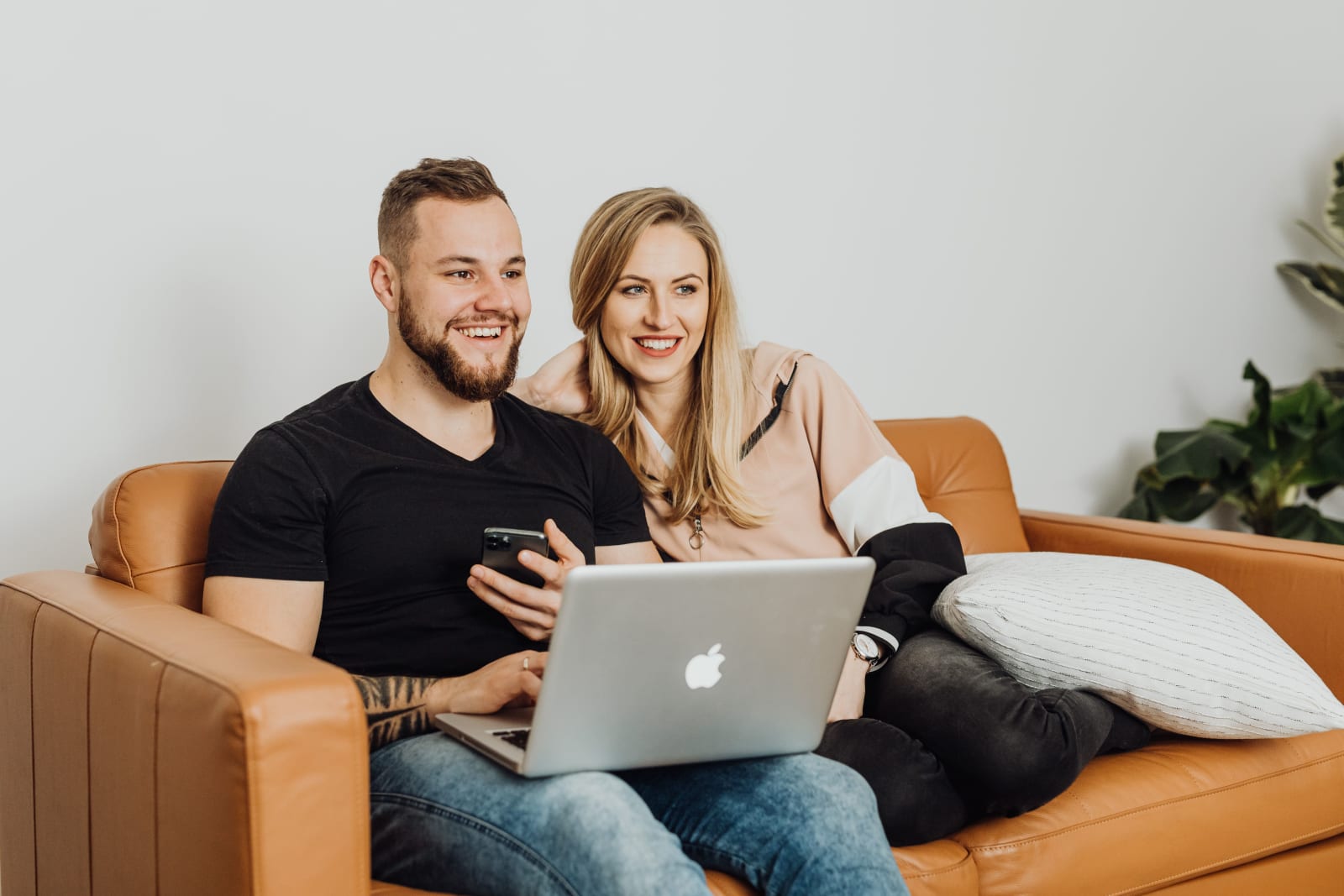 A couple on a date at home, sitting on a couch.