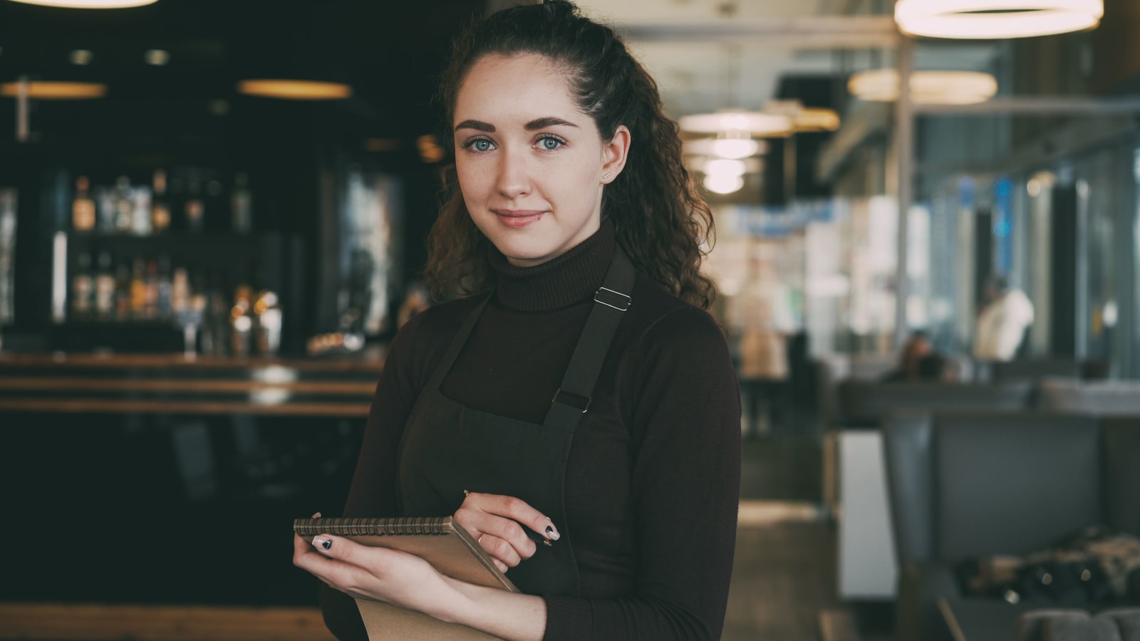 A server smiles while attending to customer.