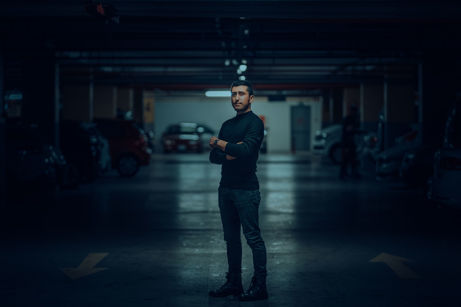 A suspicious man standing in parking lot.