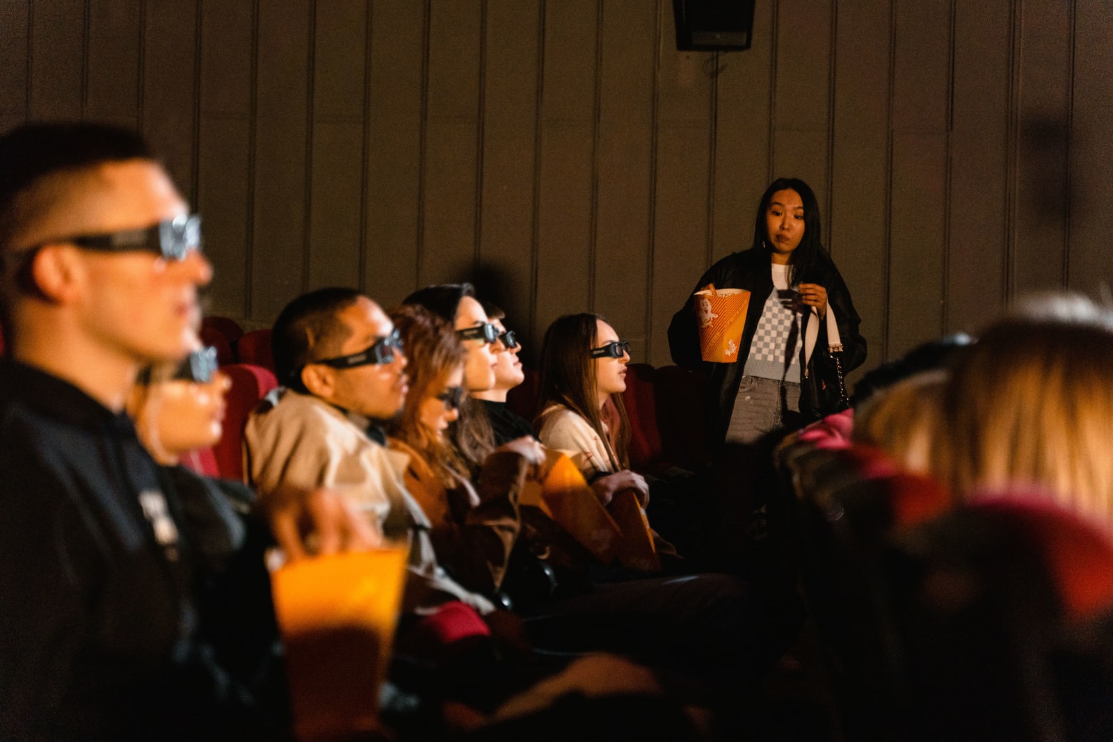 A woman staring angrily at someone in her seat in movie theater.