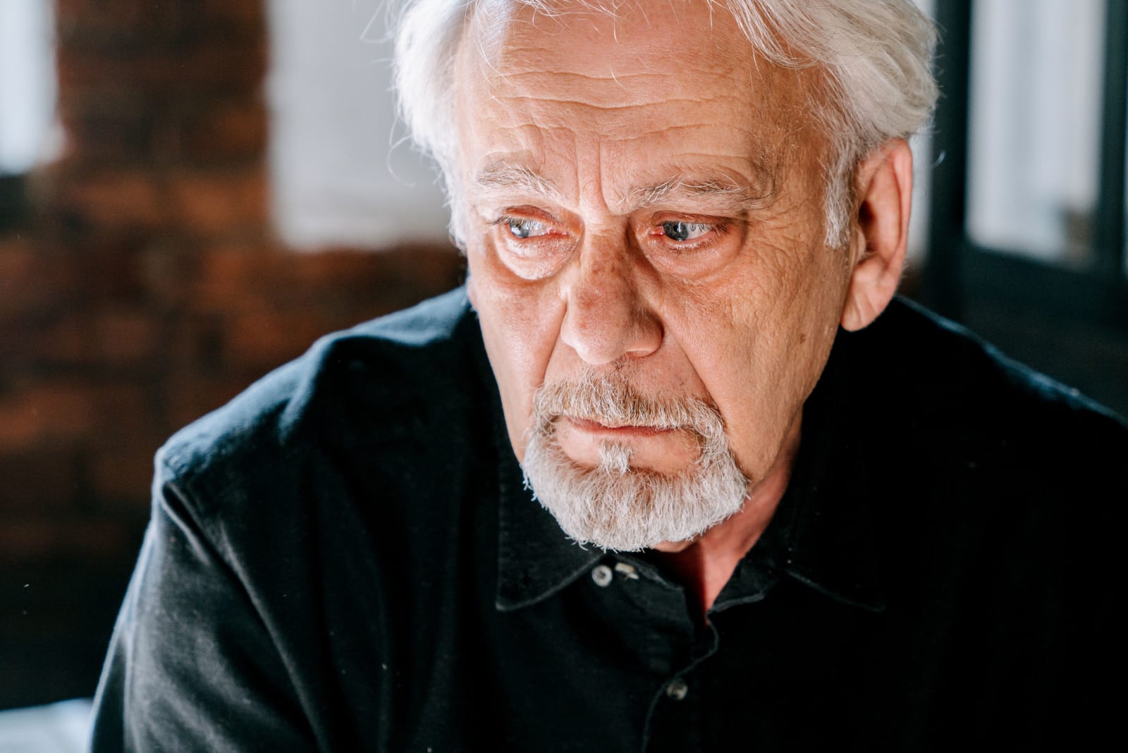 An elderly man looks emotional and heartbroken.