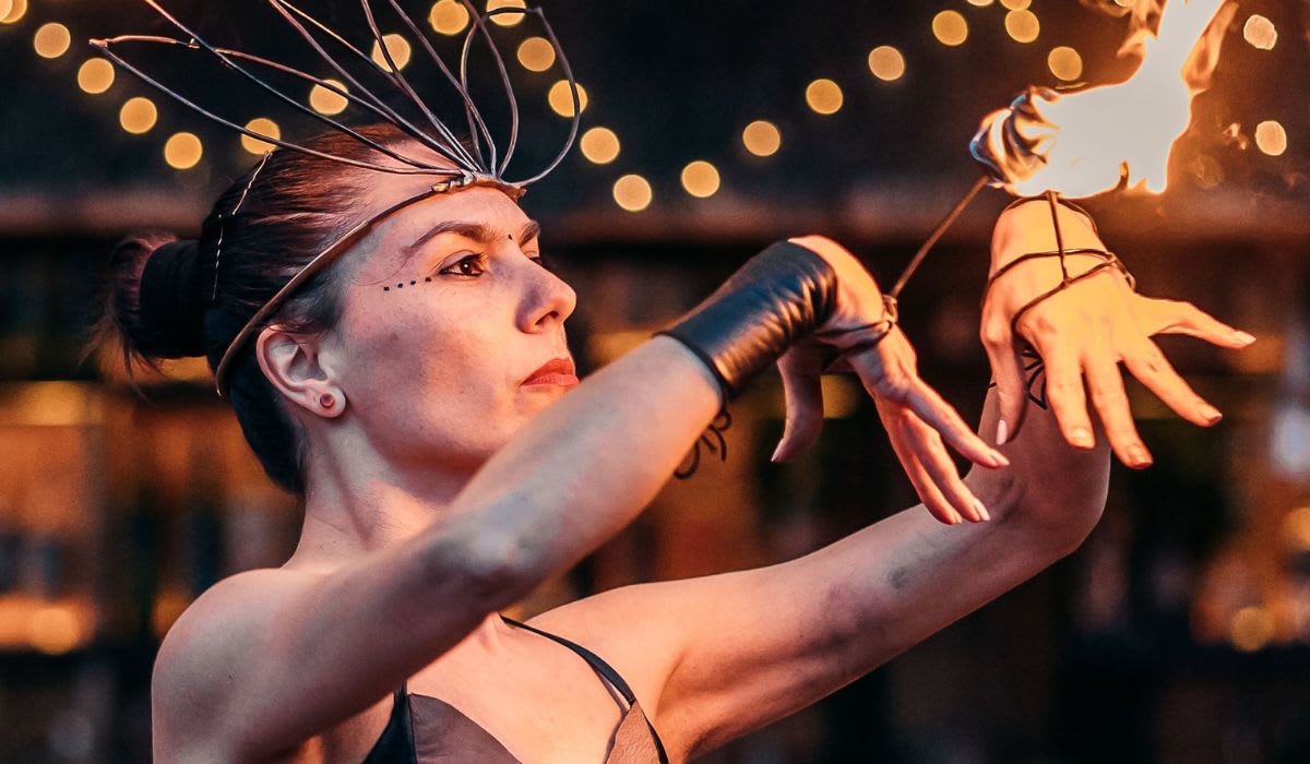 Dynamic fire performance by a woman in costume at a bar. (Representative Image Source: Pexels | Adrea Mosti)